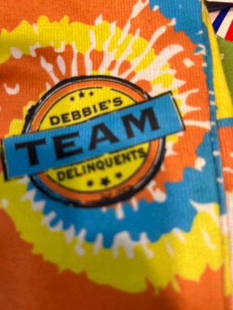 A tie dye shirt says debbie 's team delinquents