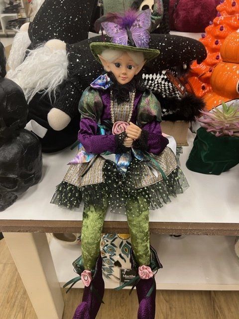 A doll in a witch costume is sitting on a table