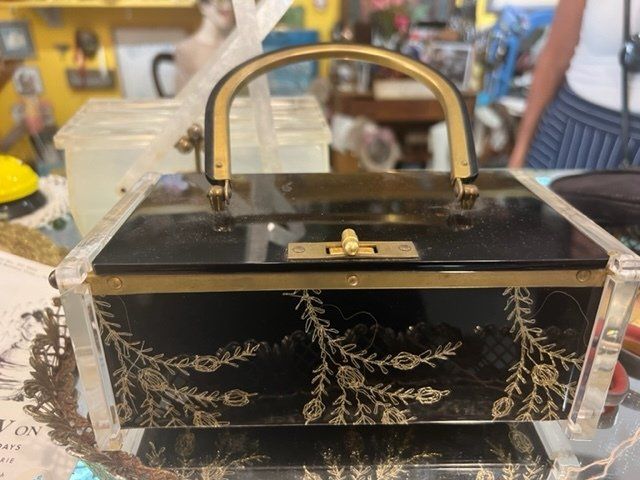 A black and gold purse with a gold handle