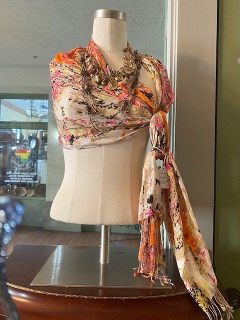 A mannequin is wearing a scarf and a necklace