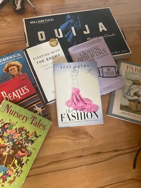 A bunch of books on a table including one called ouija