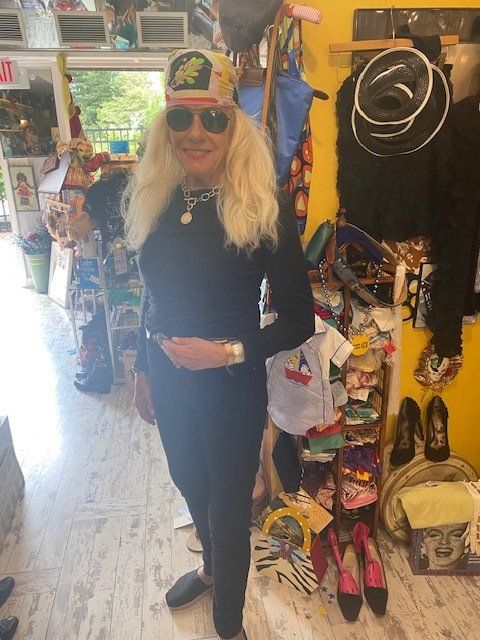 A woman wearing a hat and sunglasses is standing in a store
