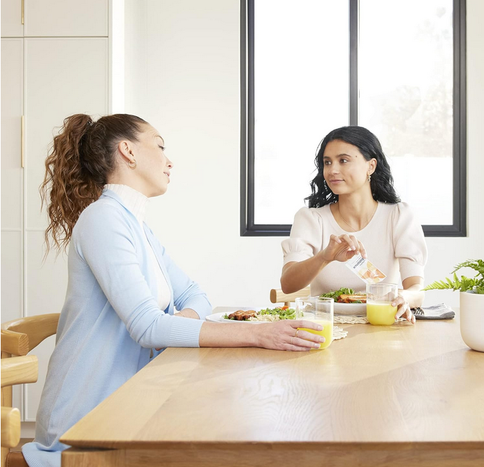 A woman is sitting and drinking Unimate