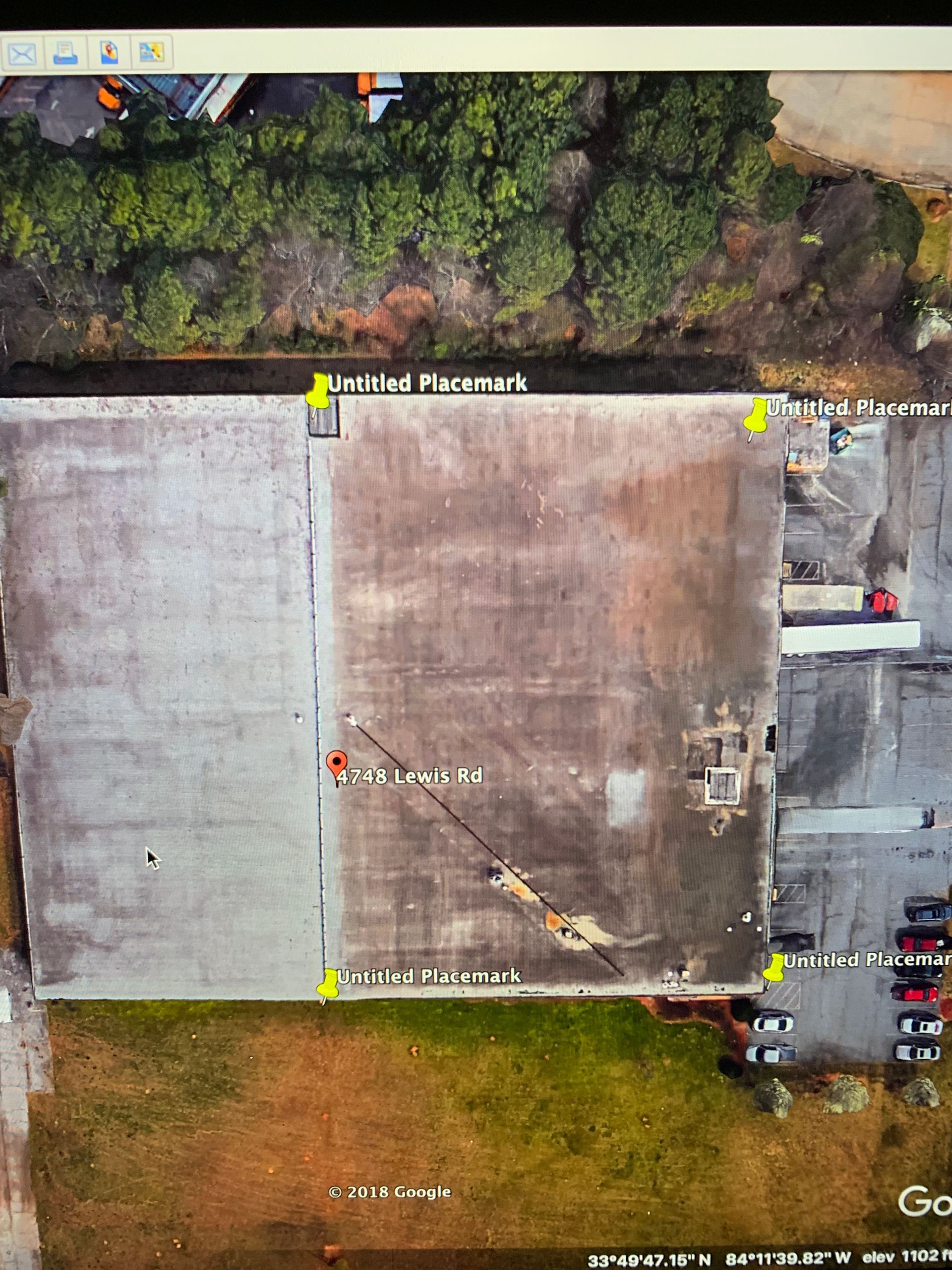 An aerial view of a large building with trees in the background