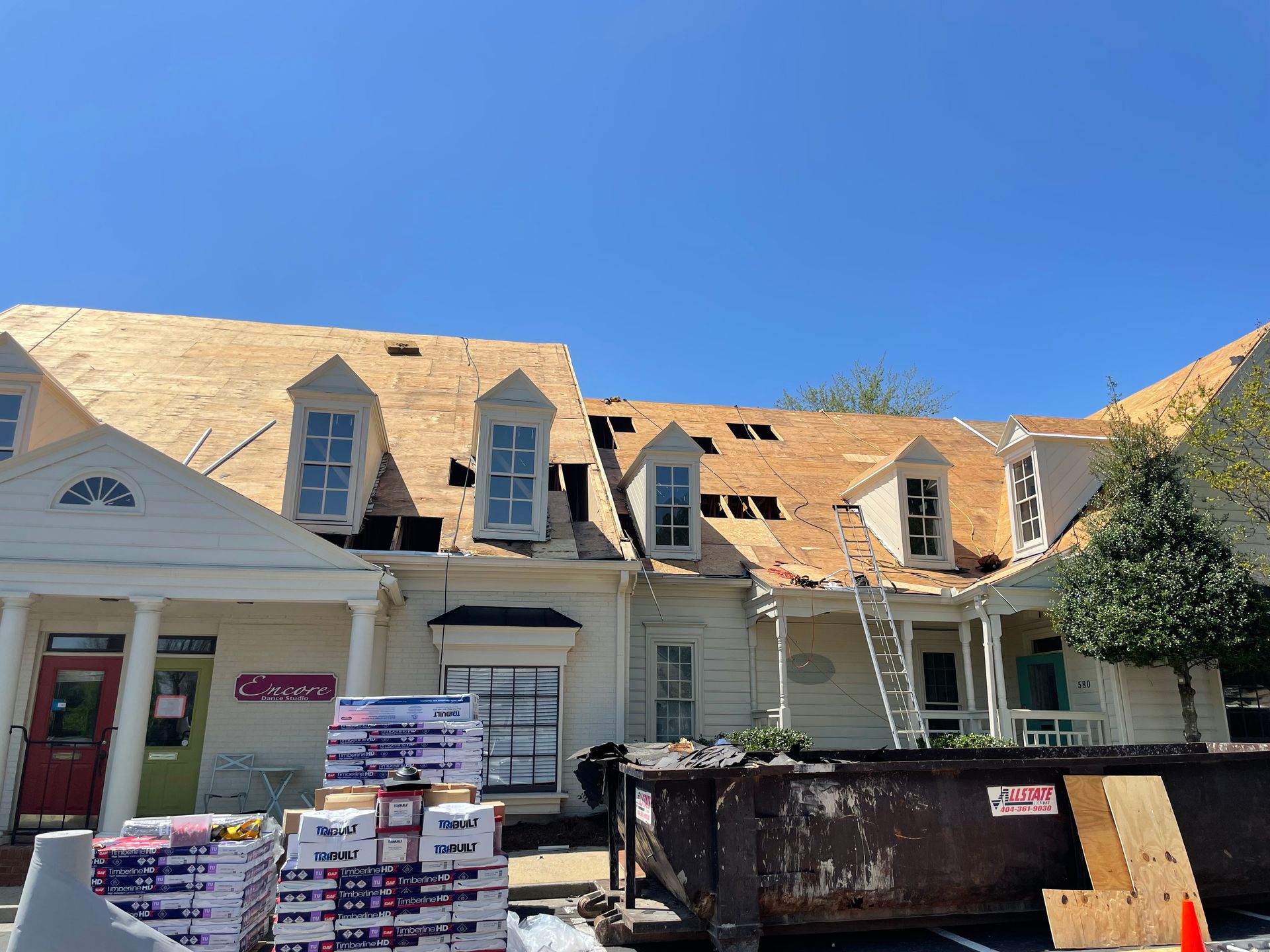 A large white house with a wooden roof is being remodeled.