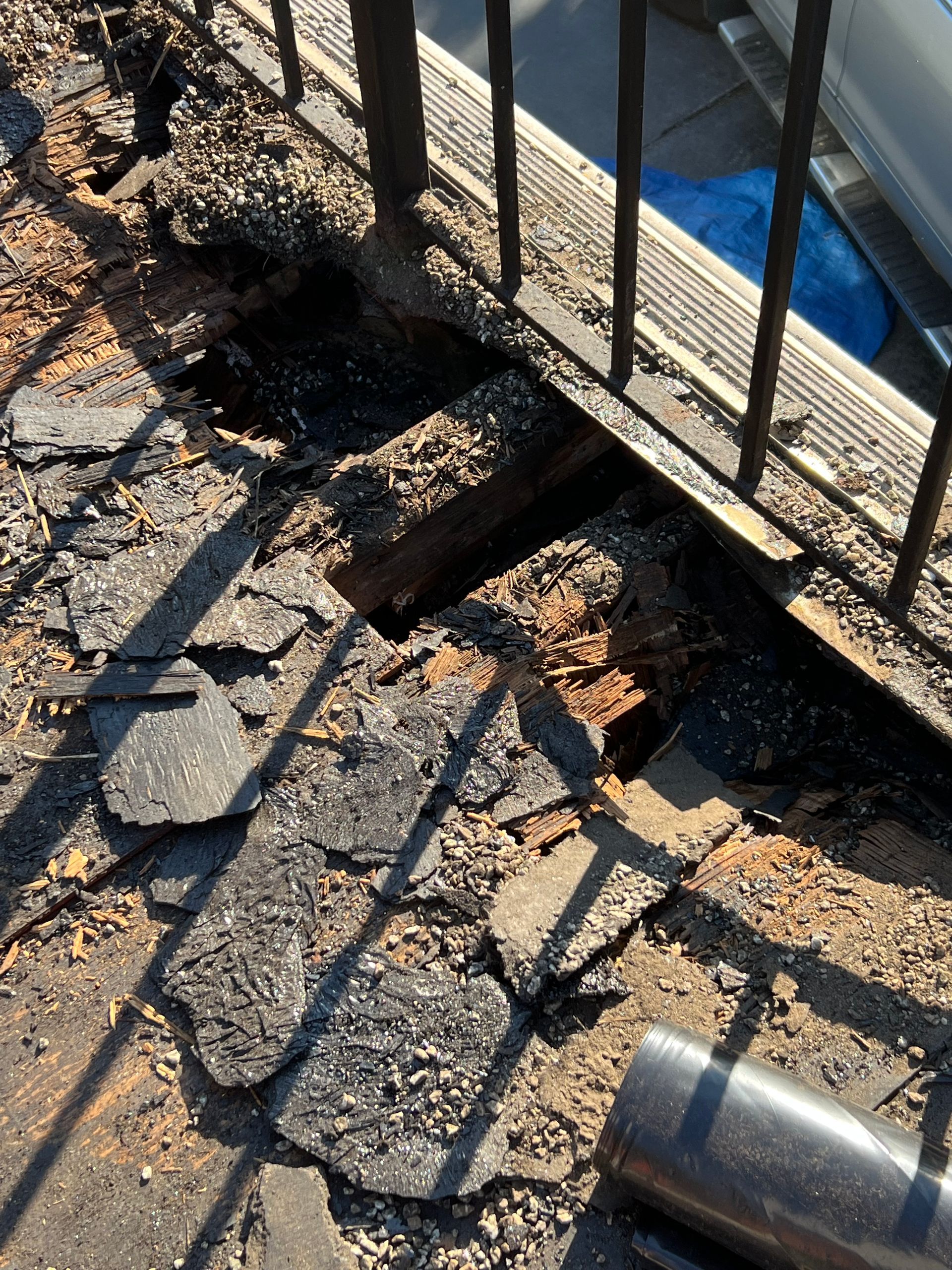A hole in the ground next to a metal railing