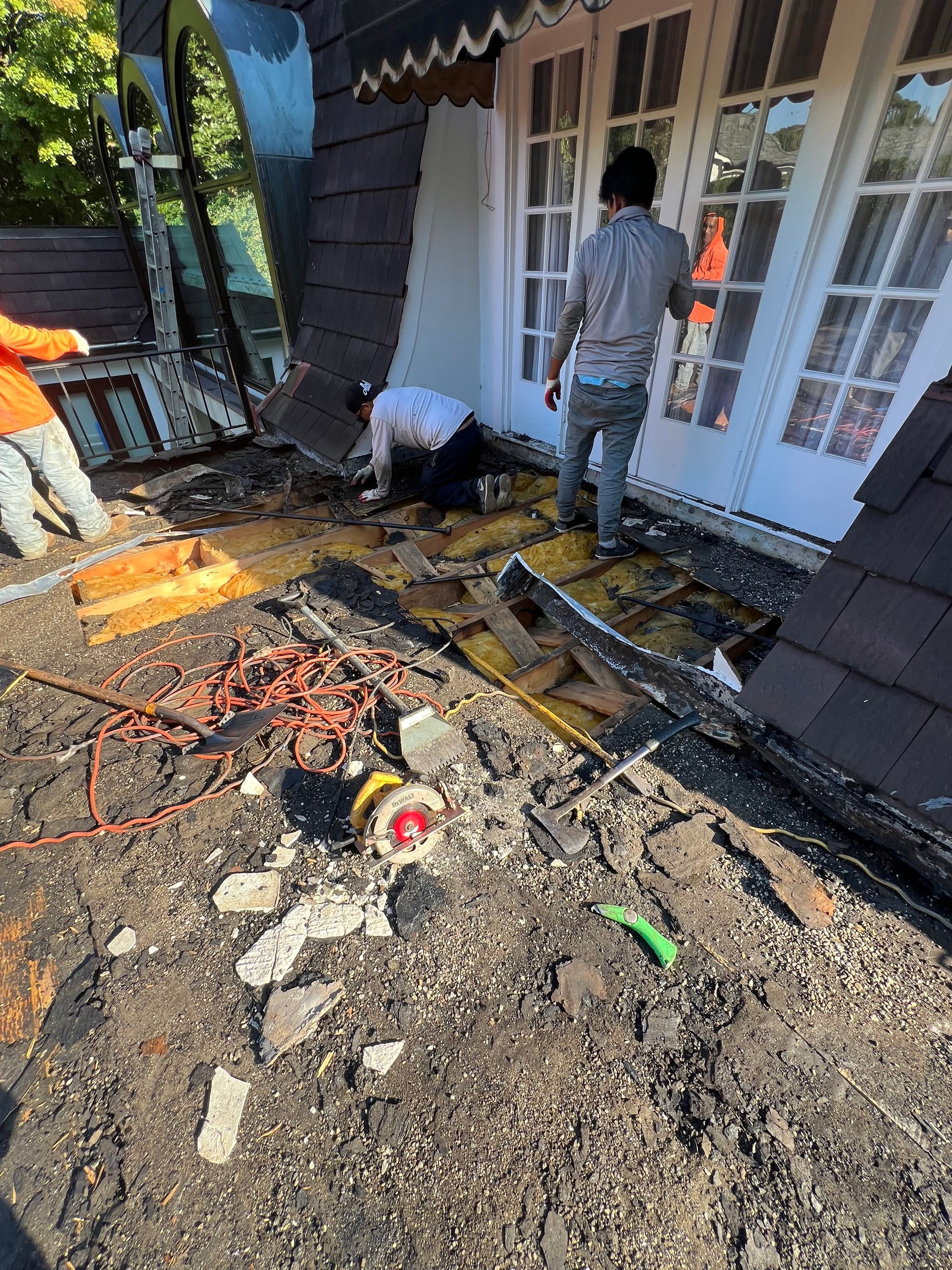 A group of men are working on the side of a house.