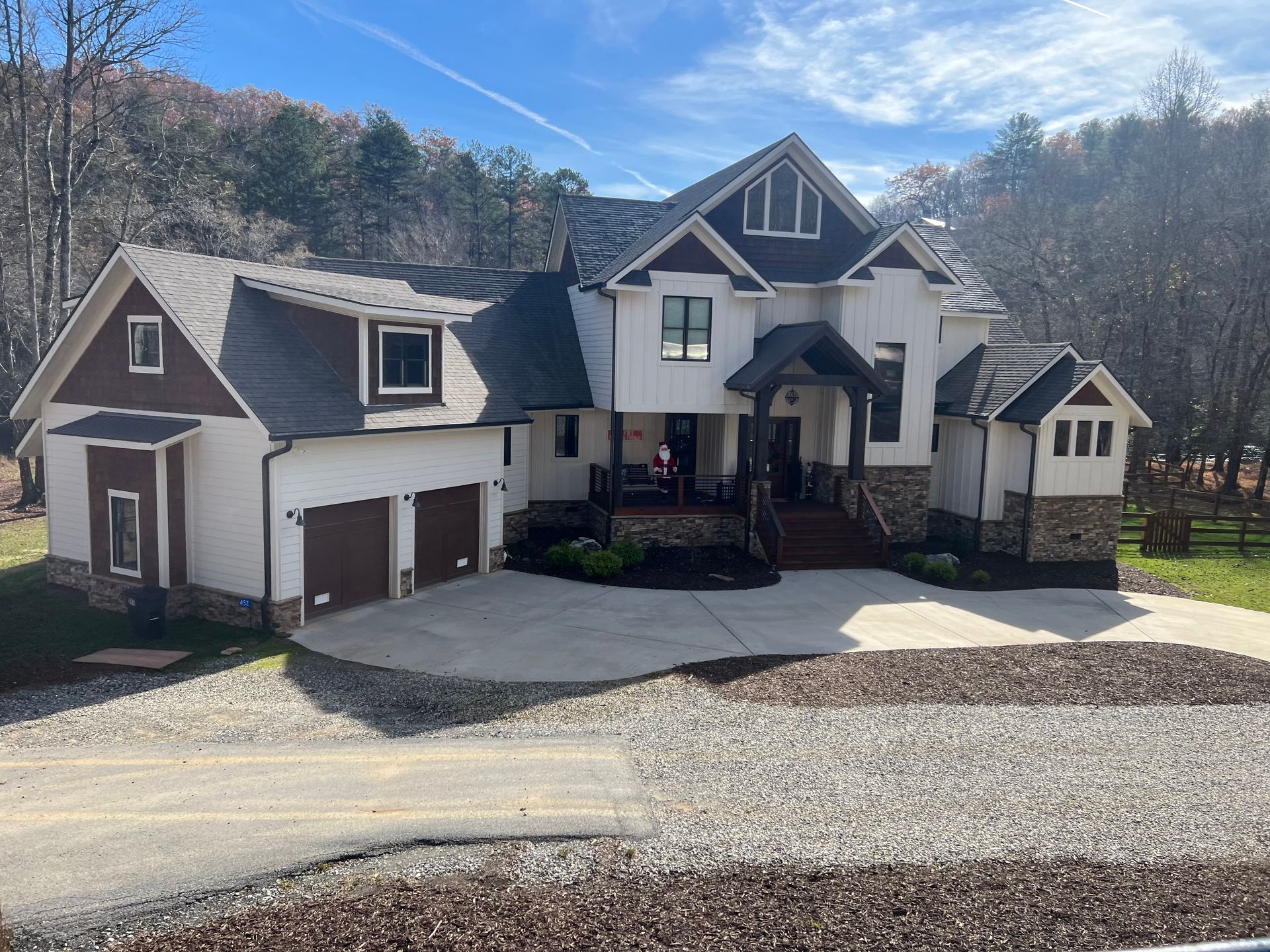 A large white and brown house with a driveway in front of it.