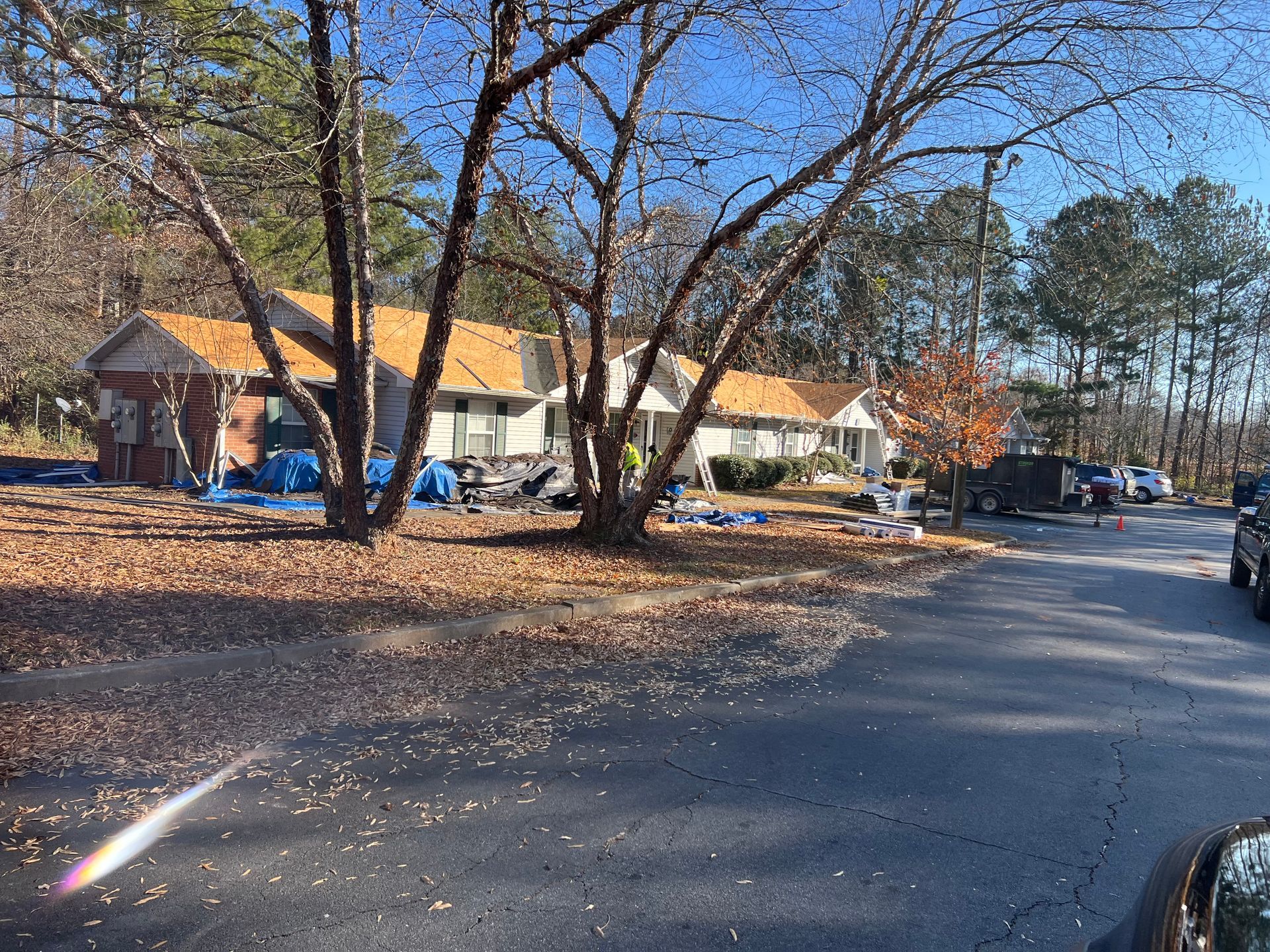 A car is parked in front of a house that is being remodeled.