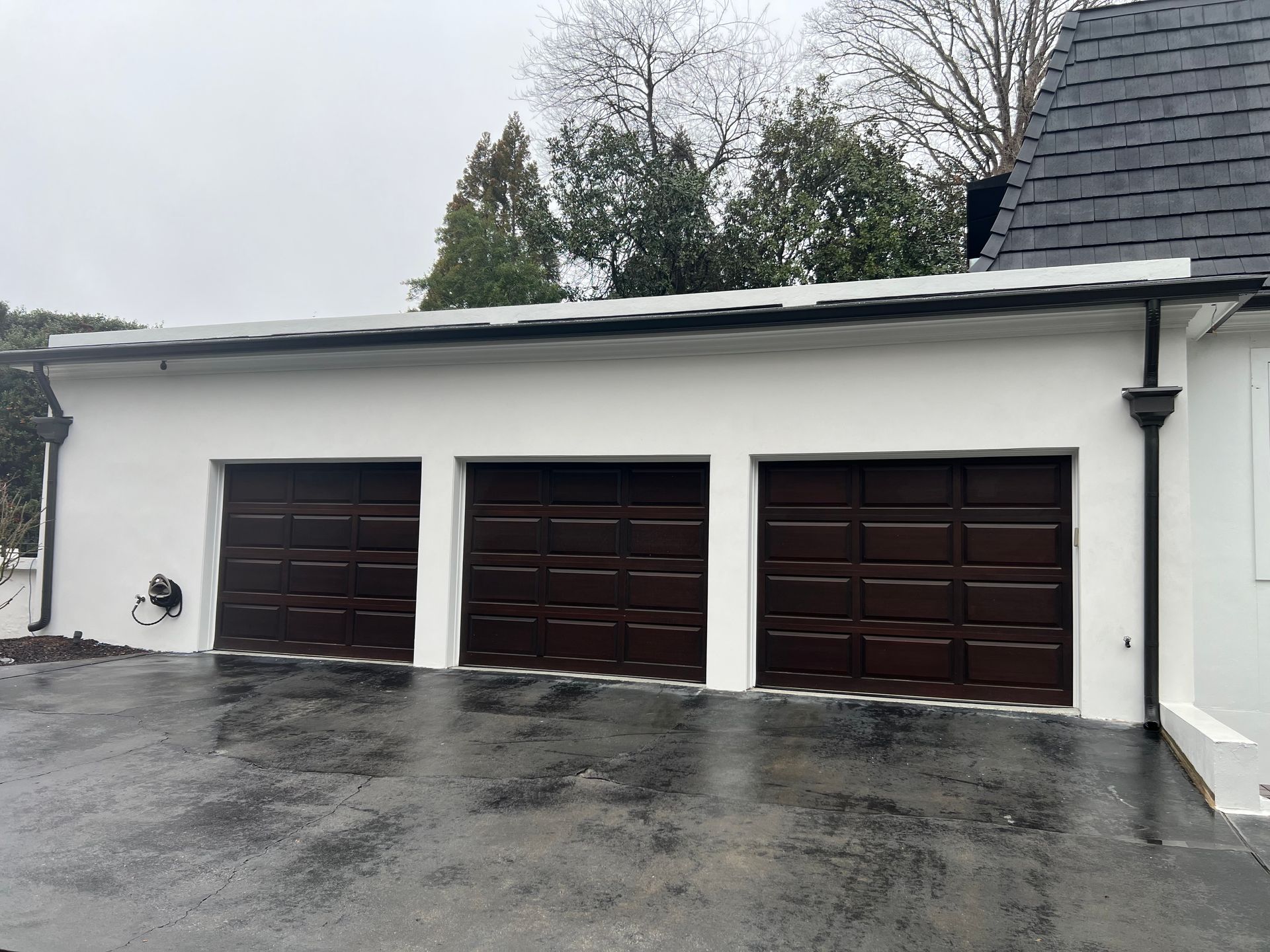 A white house with three brown garage doors