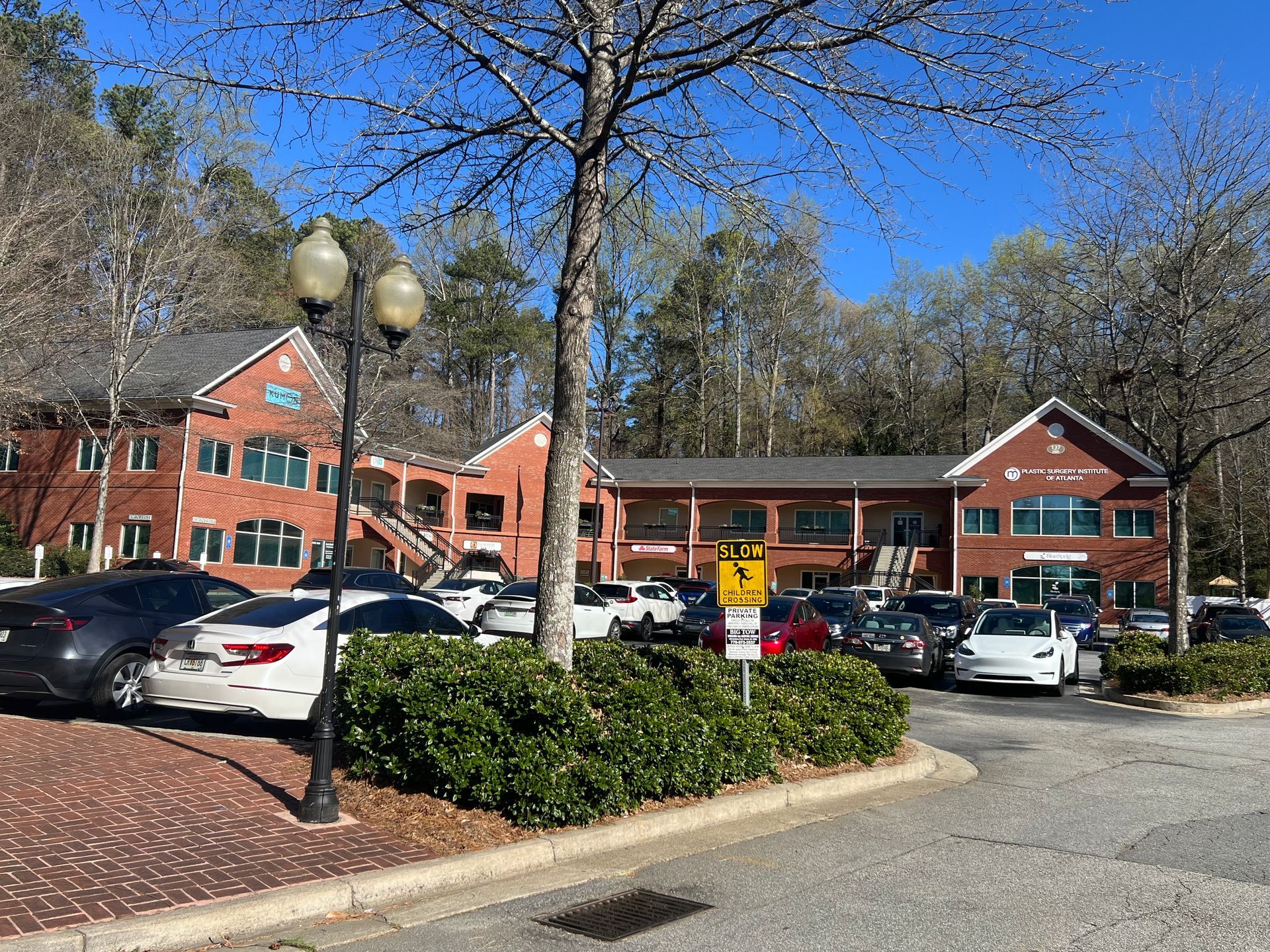 A parking lot with cars parked in front of a large building.