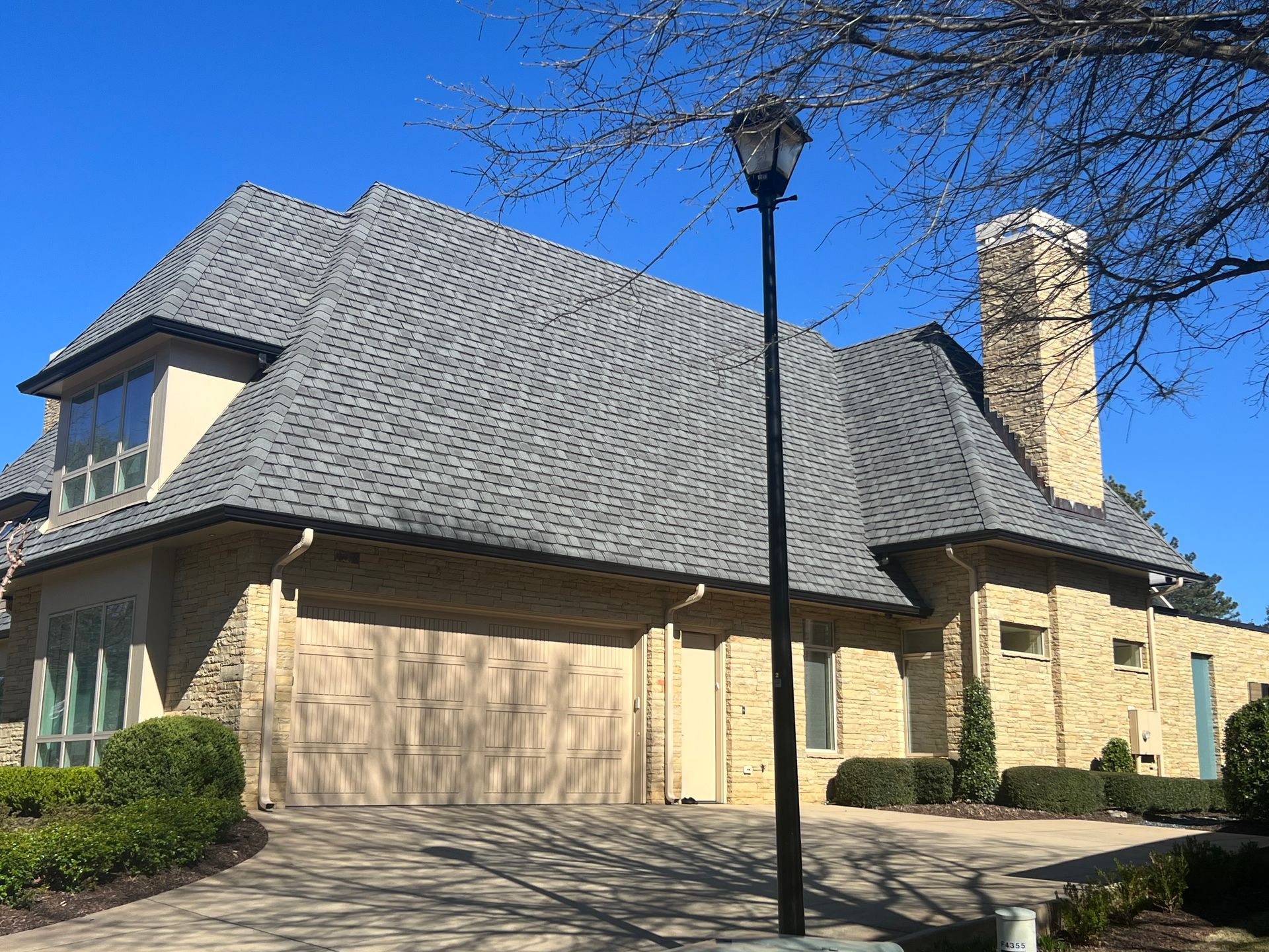 A large house with a gray roof and a chimney