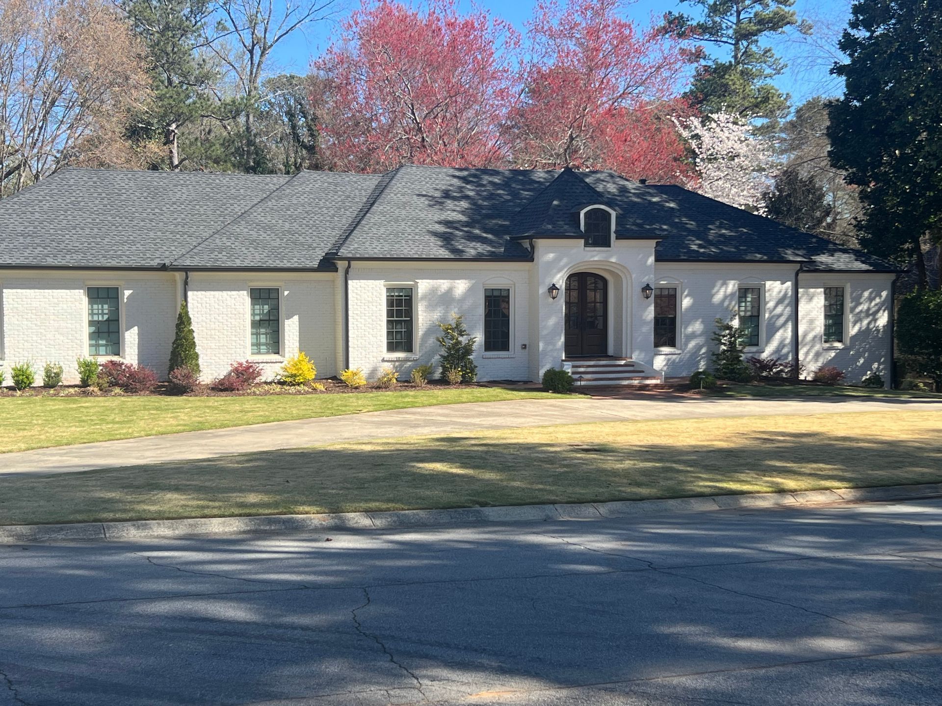 A large white brick house with a black roof