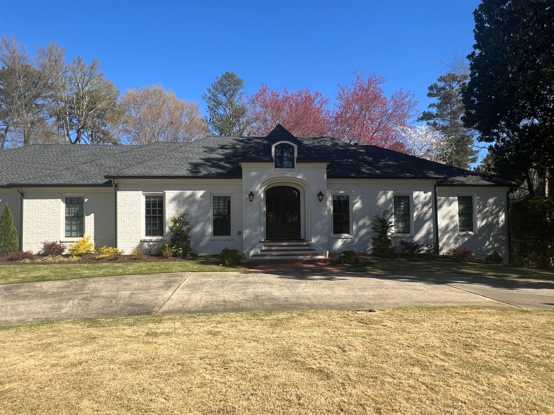A large white brick house with a black roof