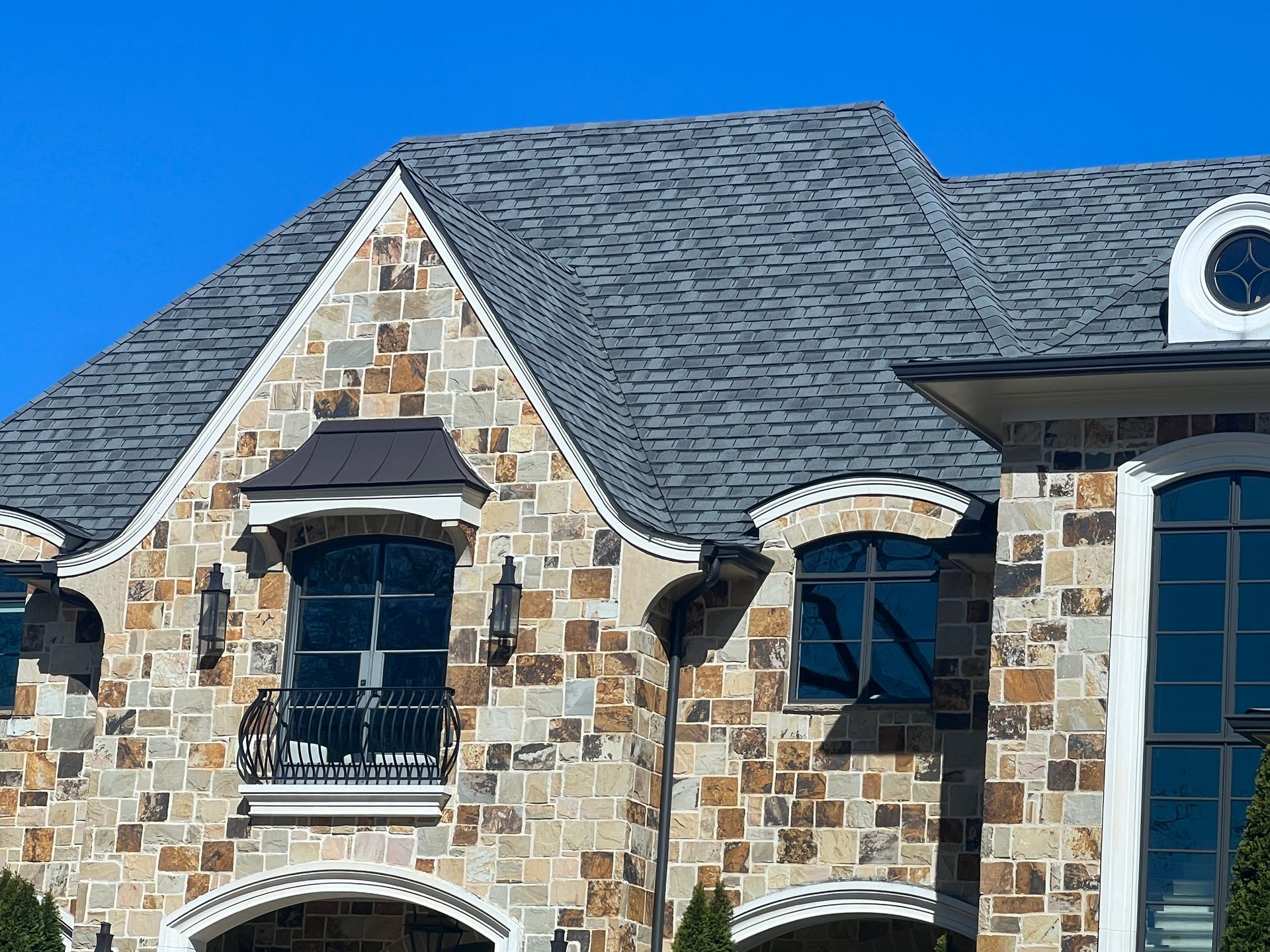 A large stone house with a clock on the roof