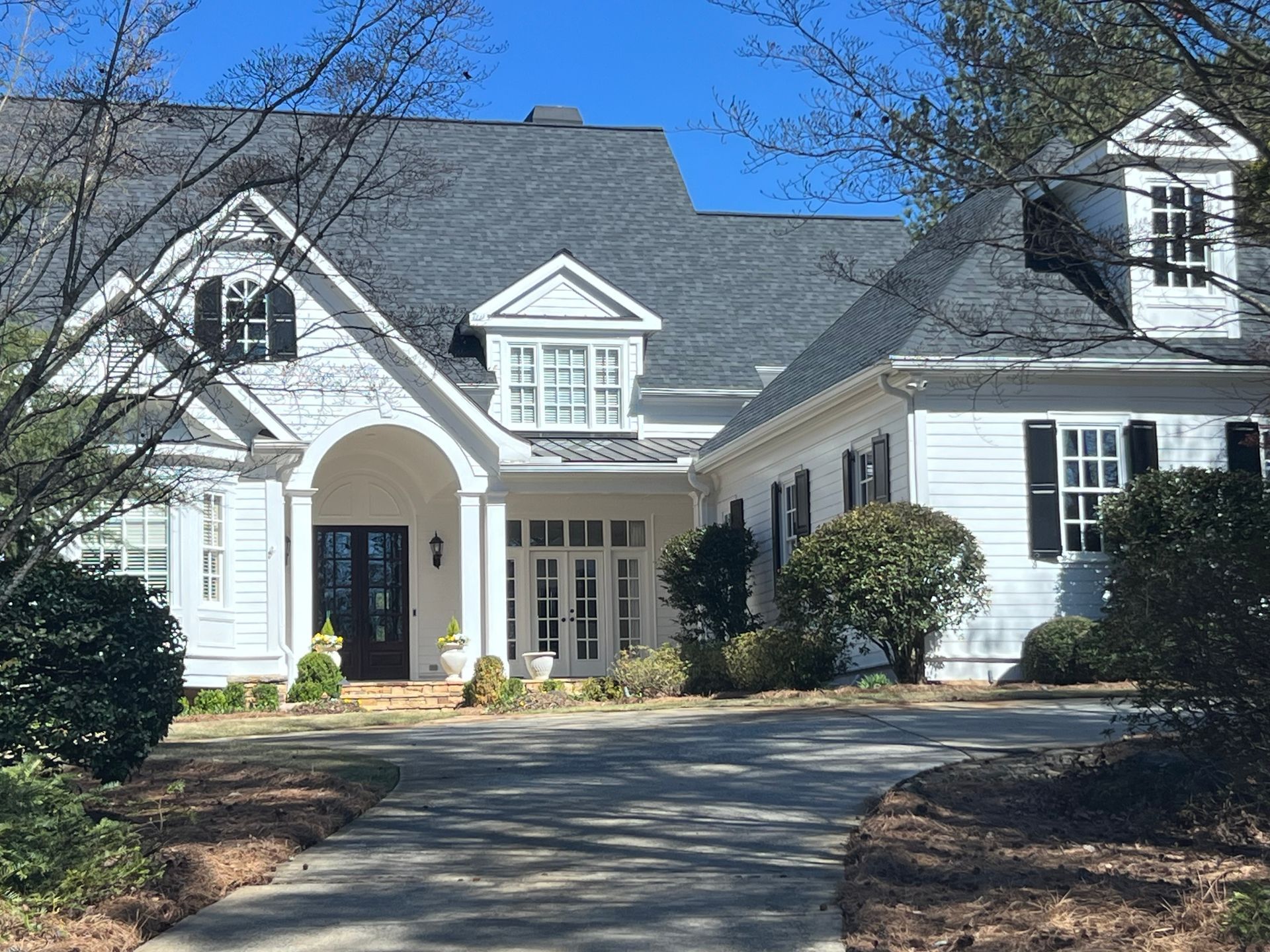 A large white house with a black roof and black shutters