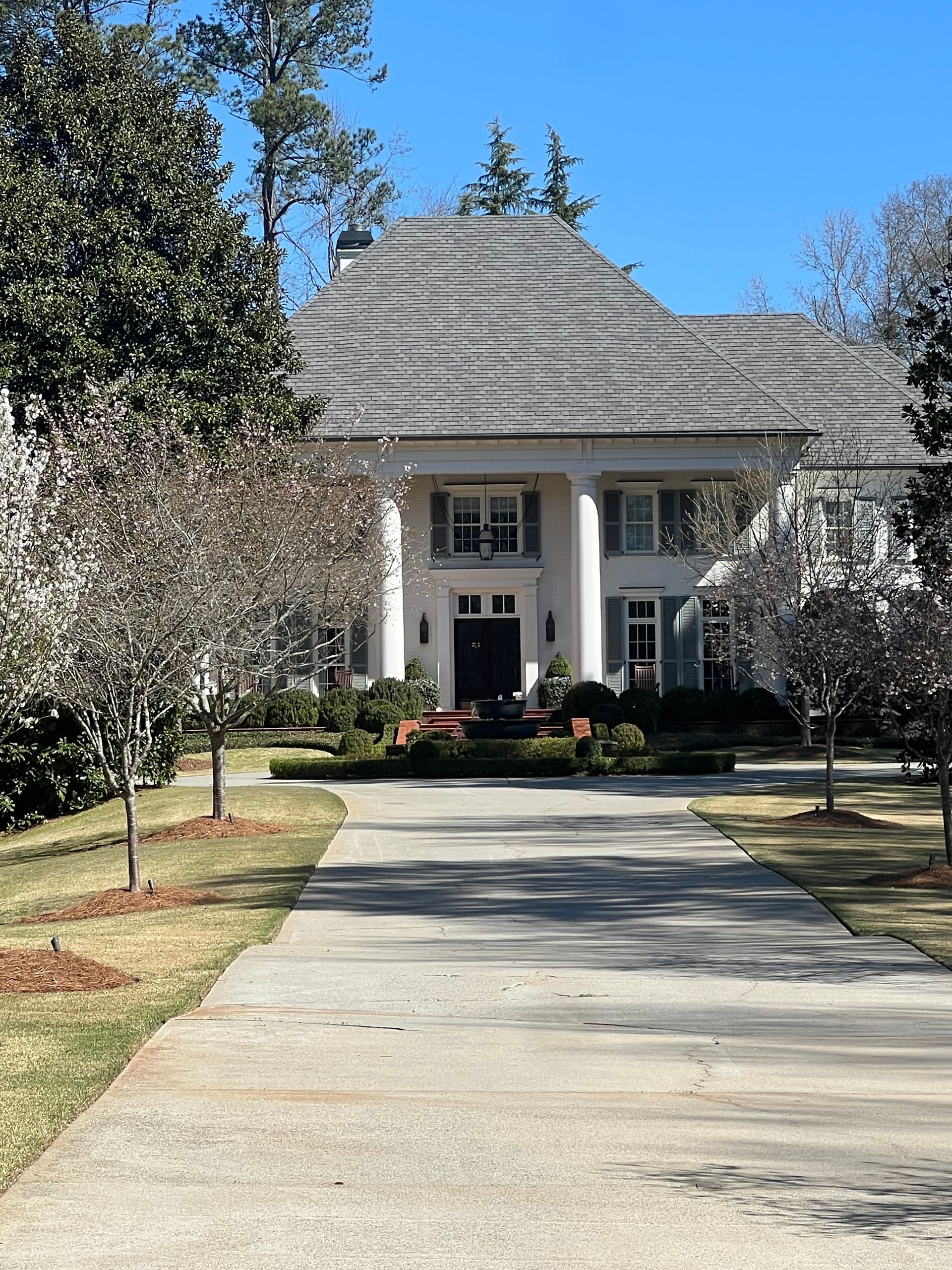 A large white house with a driveway leading to it
