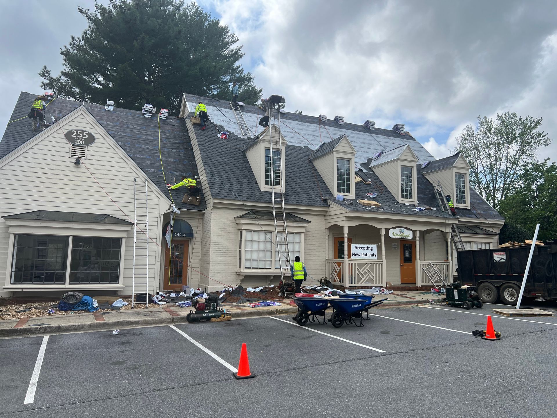A group of people are working on the roof of a house.