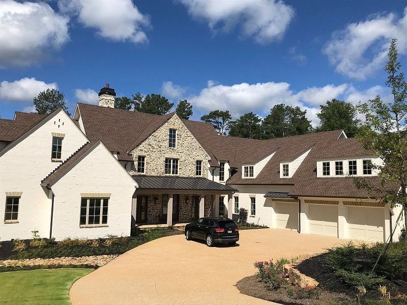 A large white house with a car parked in front of it