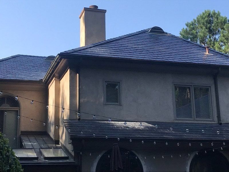A large house with a slate roof and a chimney.