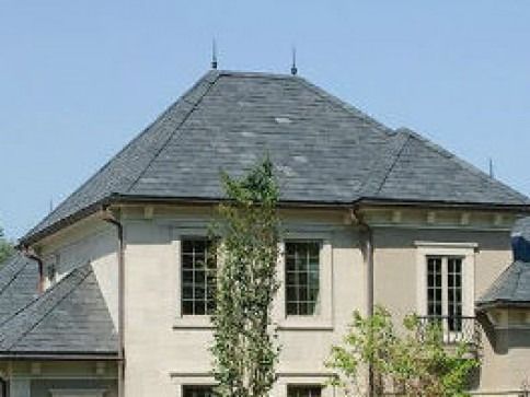 A large house with a slate roof and a lot of windows.