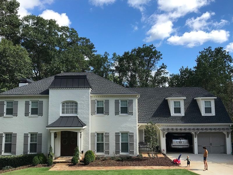 A white house with a black roof and white shutters