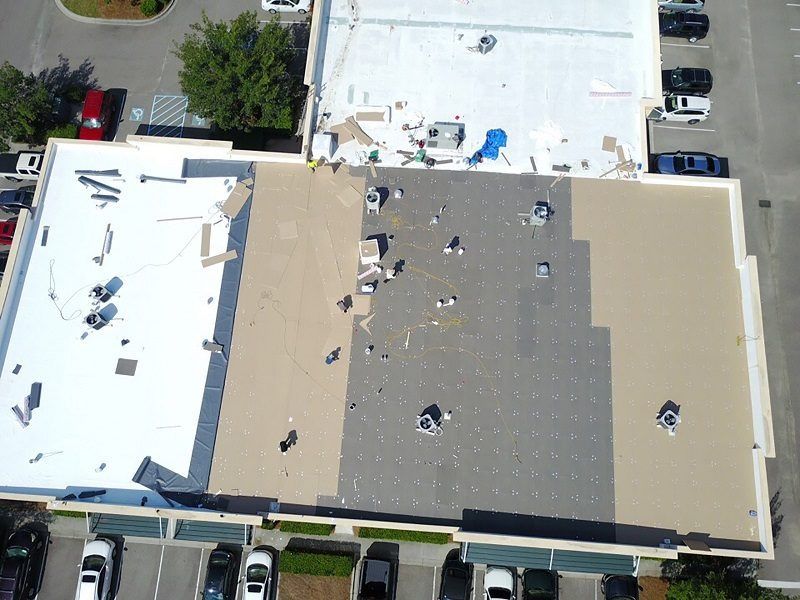 An aerial view of a building with a roof that is being repaired
