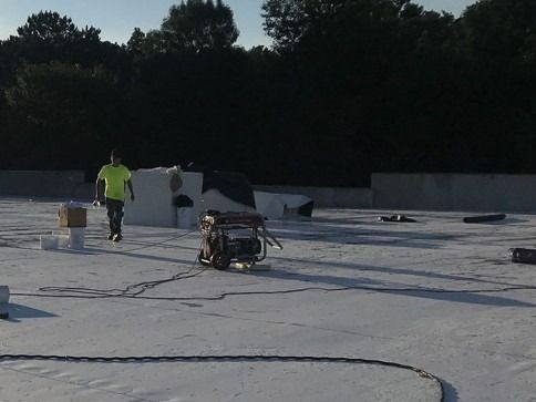 A man in a yellow shirt is walking on a white roof