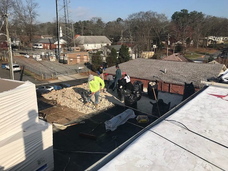 A group of people are working on the roof of a building.