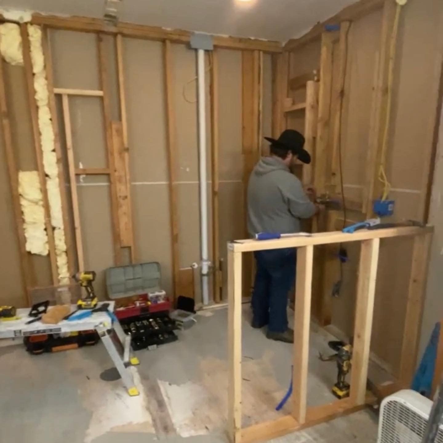 A man is working on a wall in a room