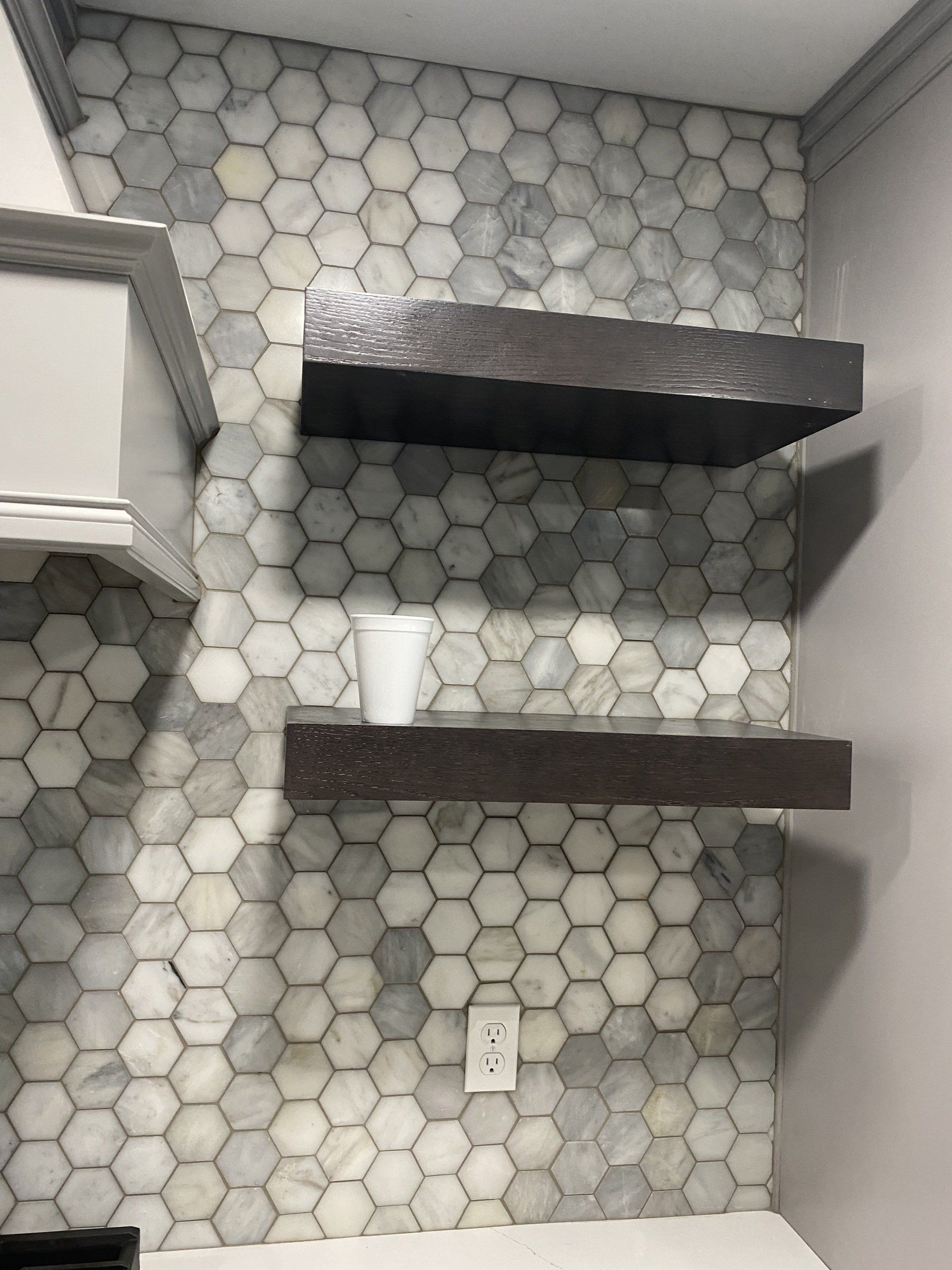 A kitchen with hexagonal tiles and floating shelves