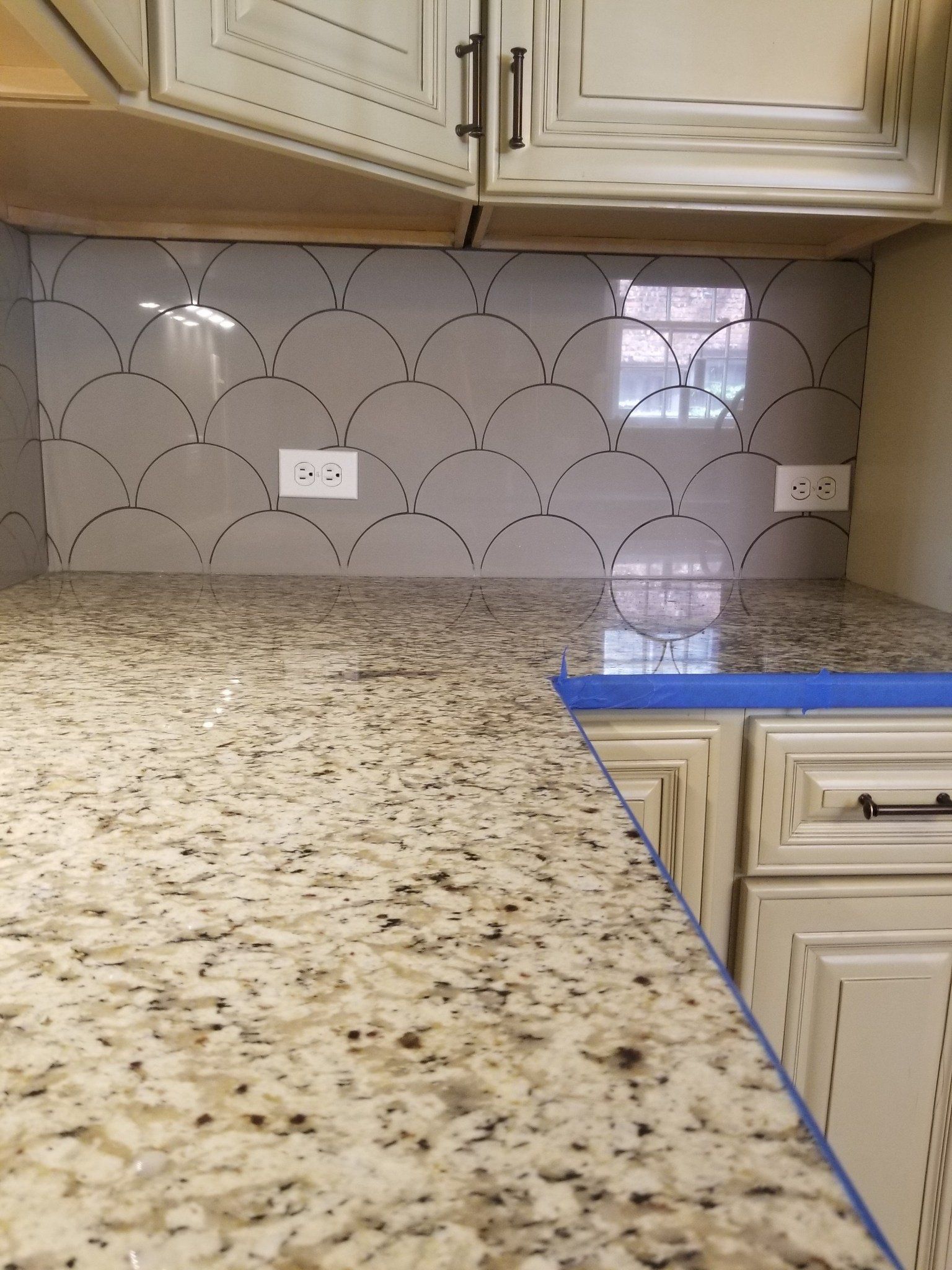 A kitchen with granite counter tops and white cabinets