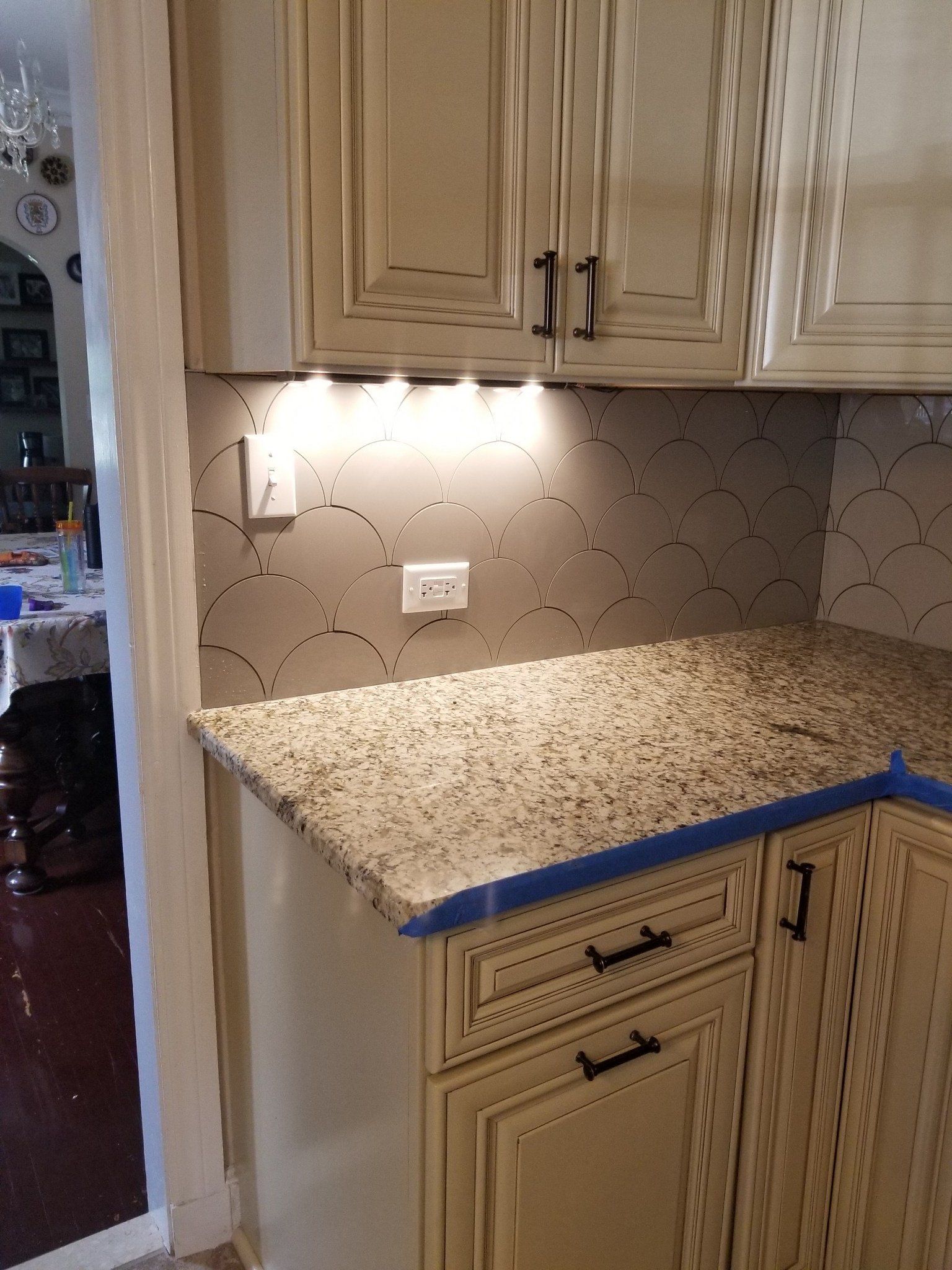 A kitchen with granite counter tops and white cabinets