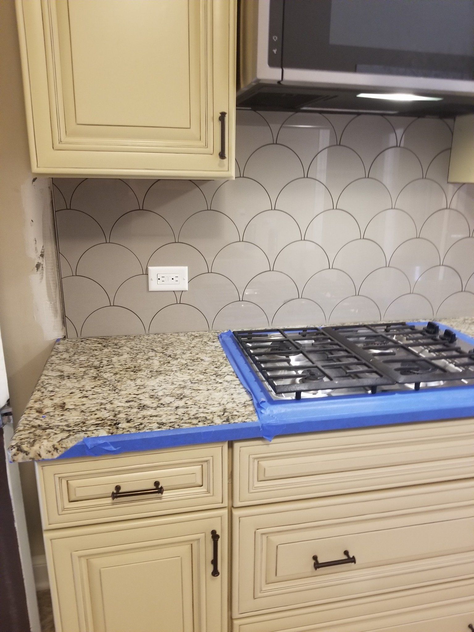 A kitchen with a stove top oven and a microwave.