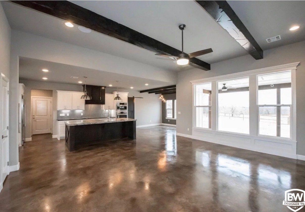A large empty room with hardwood floors and a ceiling fan.
