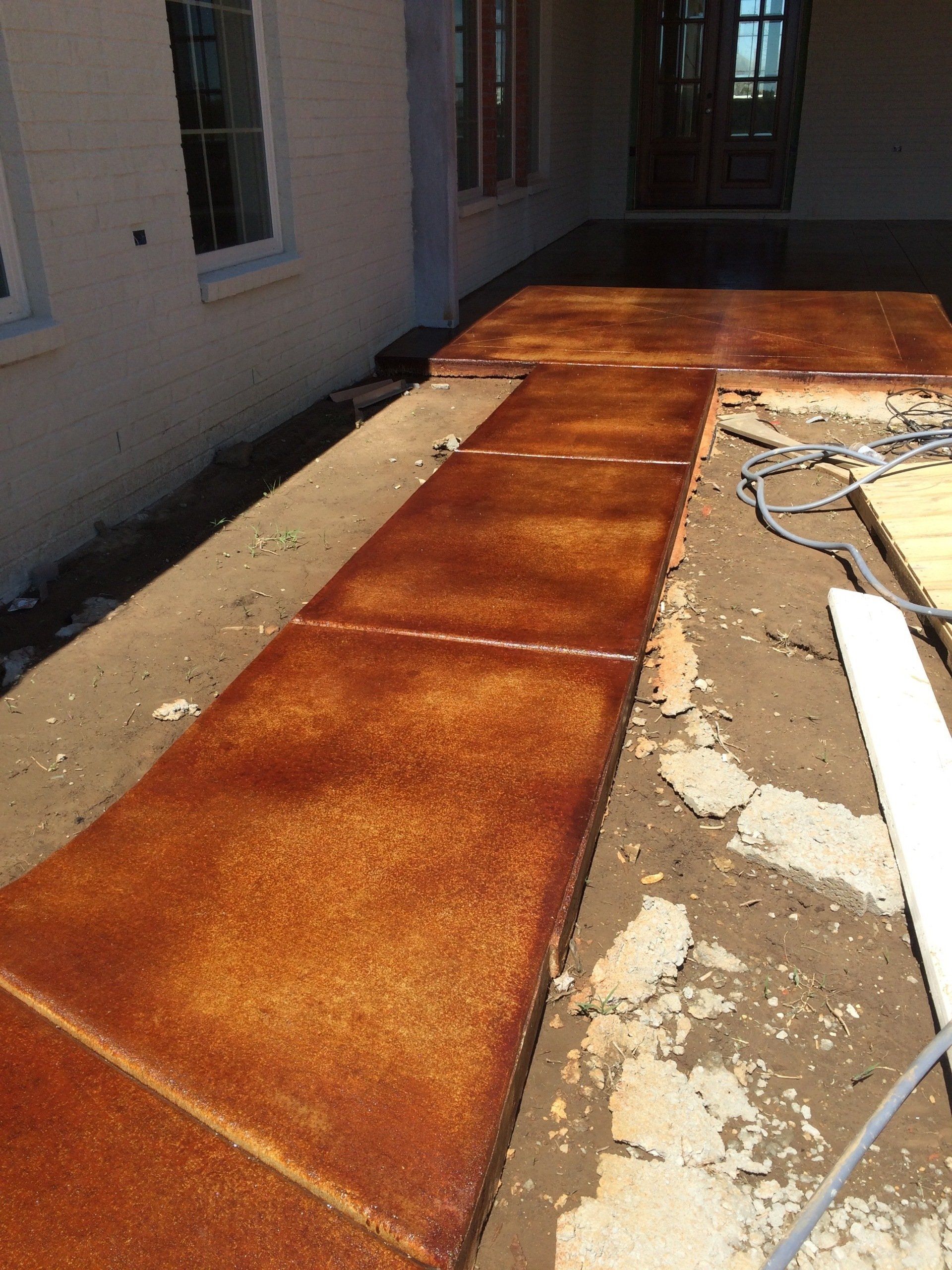 A concrete walkway is being built in front of a house