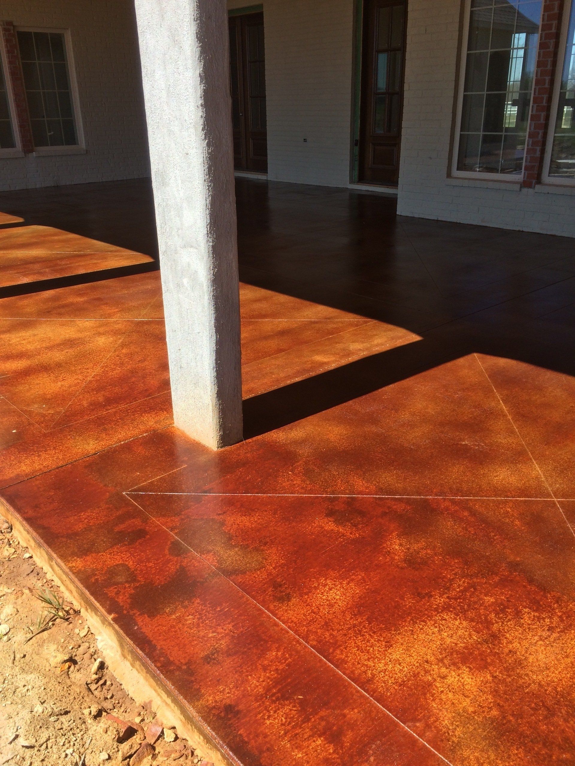 A patio with a concrete floor and a pillar in the background.