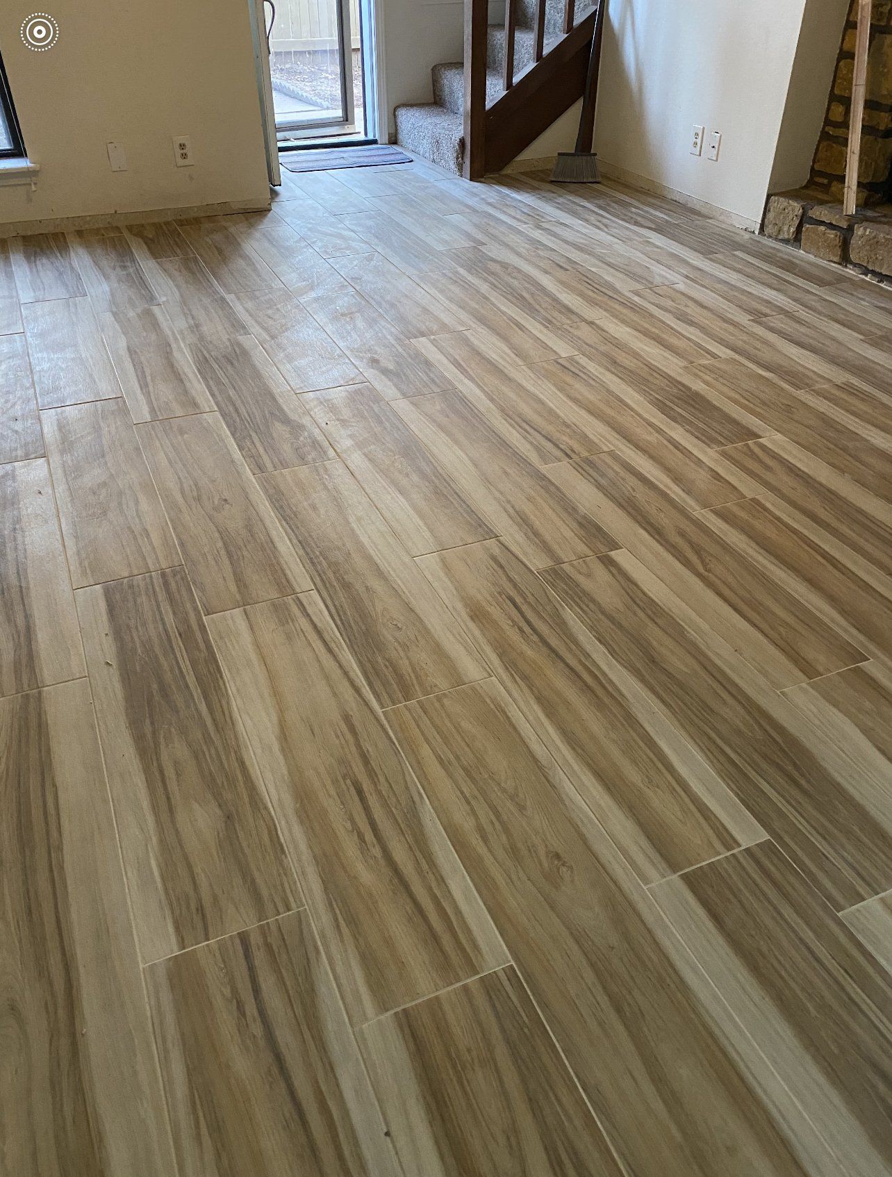 A living room with a wooden floor and stairs.