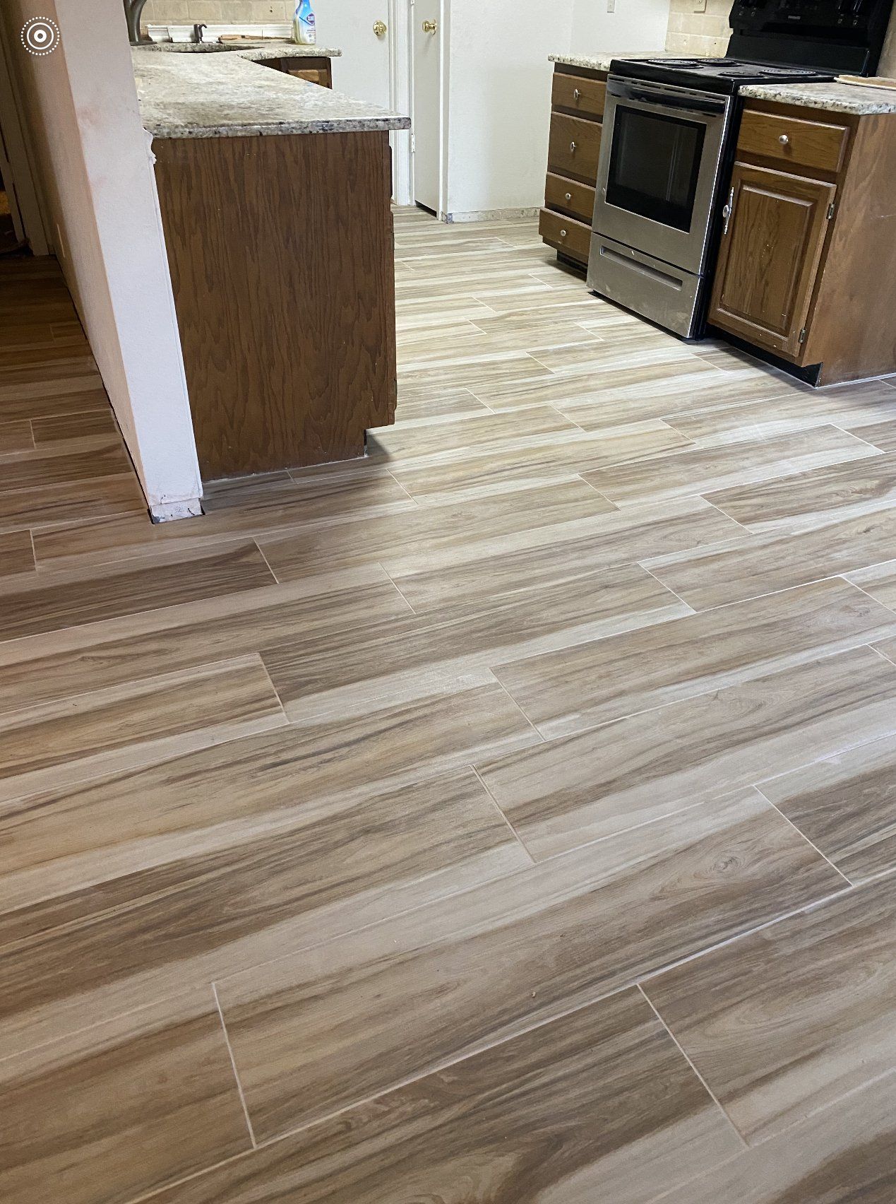 A kitchen with a wooden floor and stainless steel appliances.