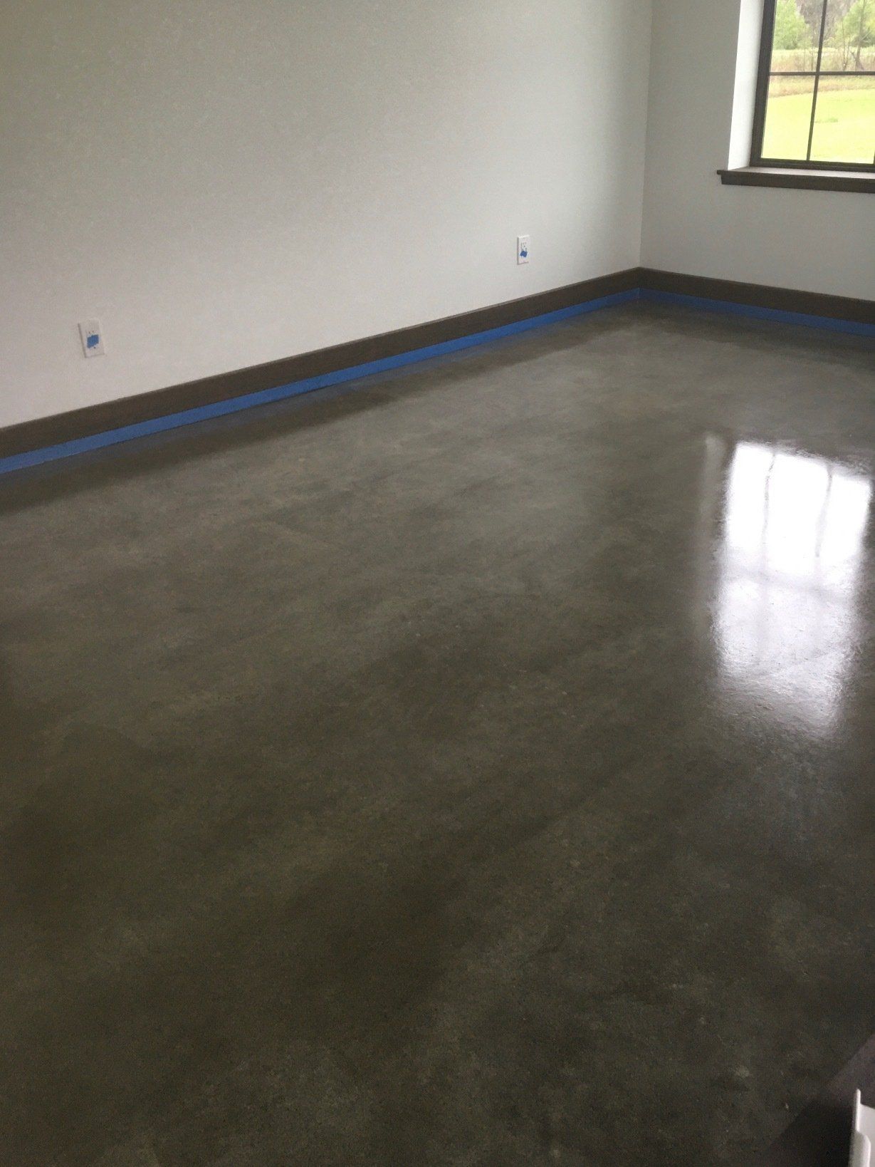 A room with a concrete floor and a window.