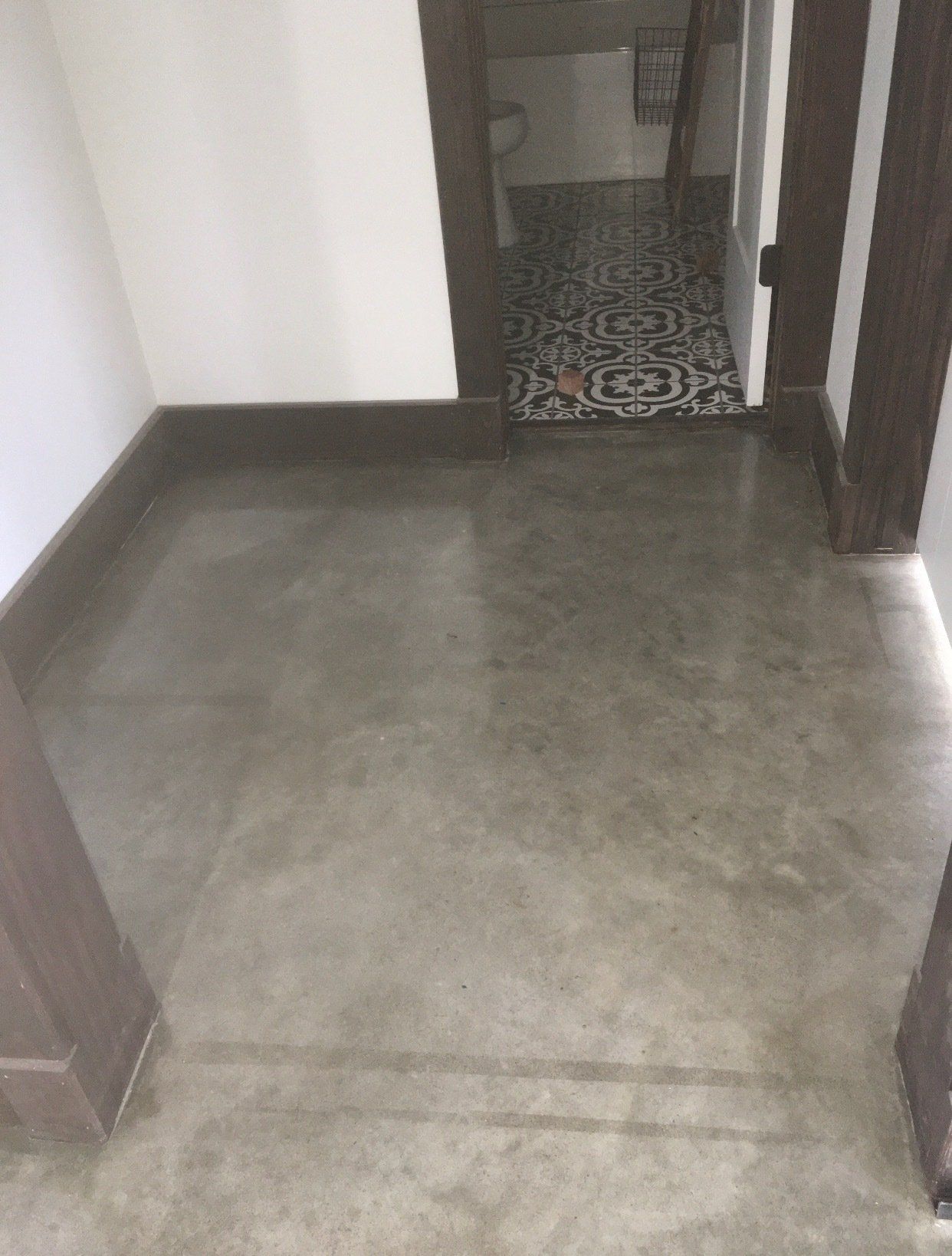 A hallway with a concrete floor and a tiled floor.