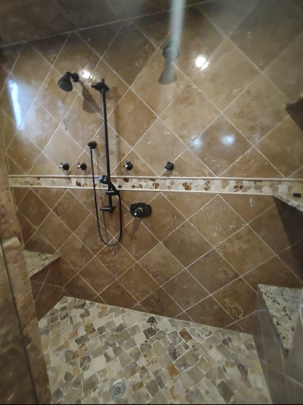 A bathroom with a walk in shower and a tiled floor.