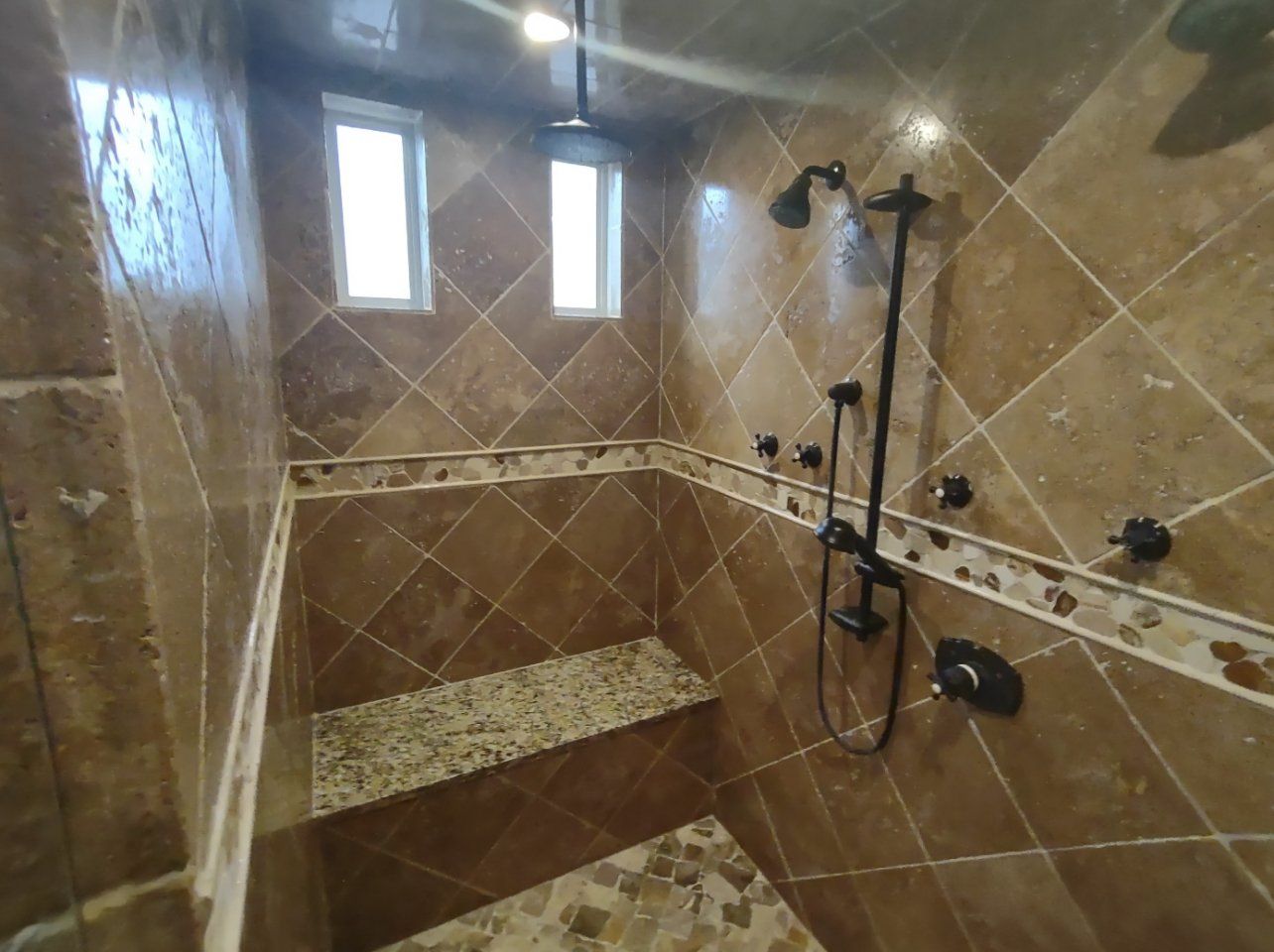 A bathroom with a walk in shower and a window.