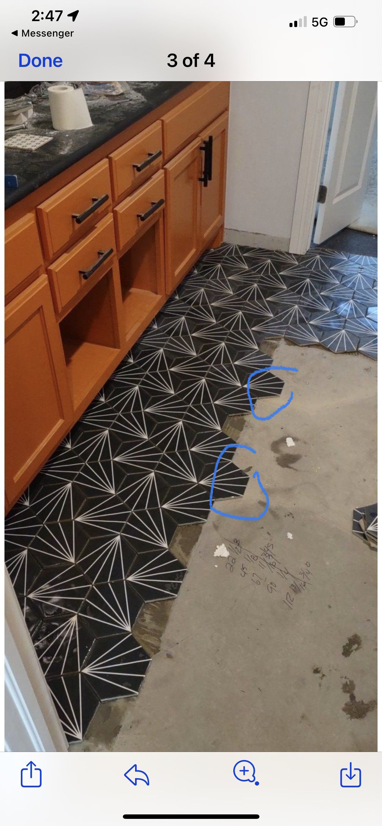 A bathroom with a black and white tile floor and wooden cabinets.