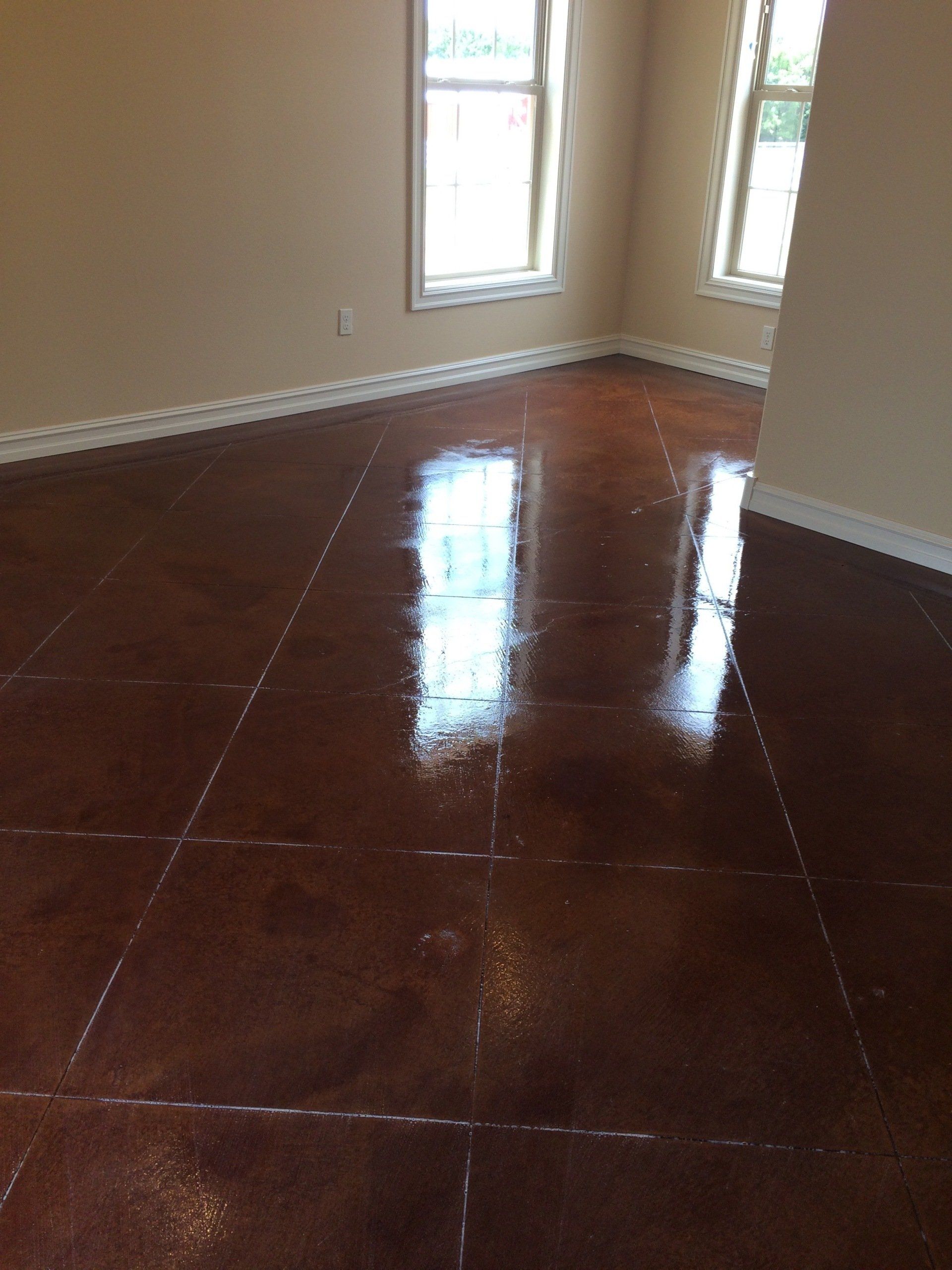 A room with a shiny concrete floor and two windows