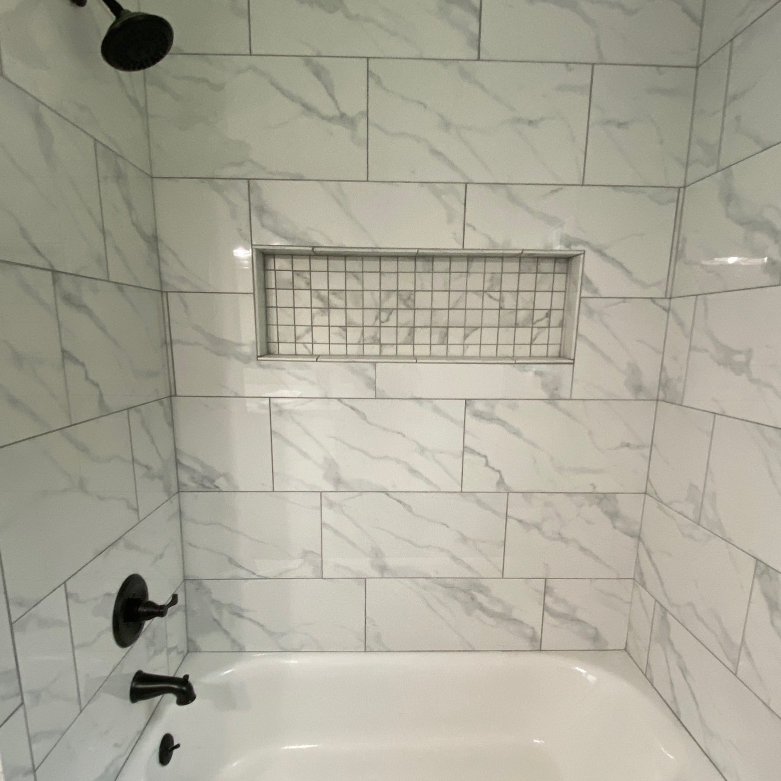 Carrera marble look alike, 12x24 tile, large shampoo shelf, random pattern bathtub tile