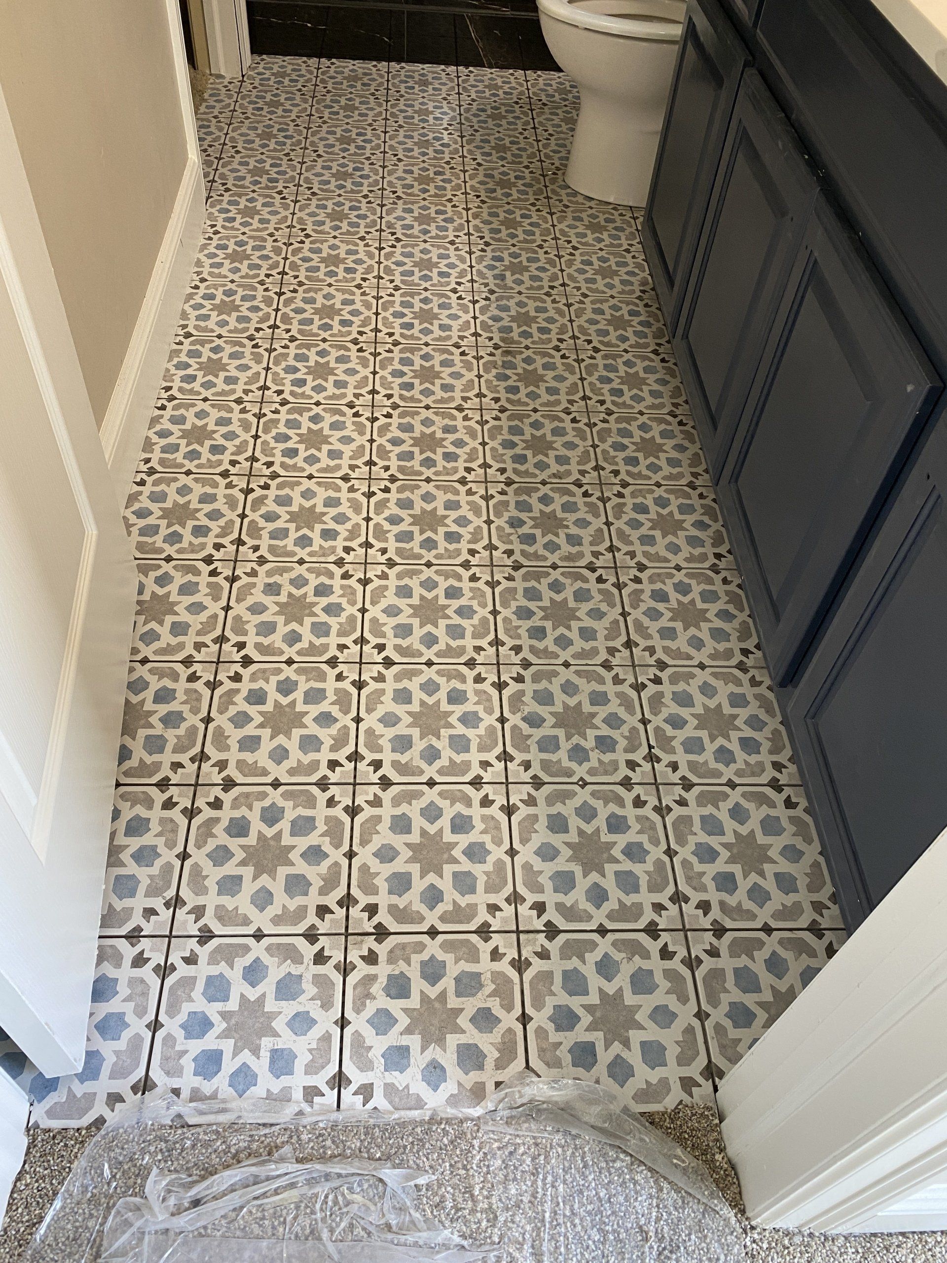 A bathroom with a tiled floor and a toilet.