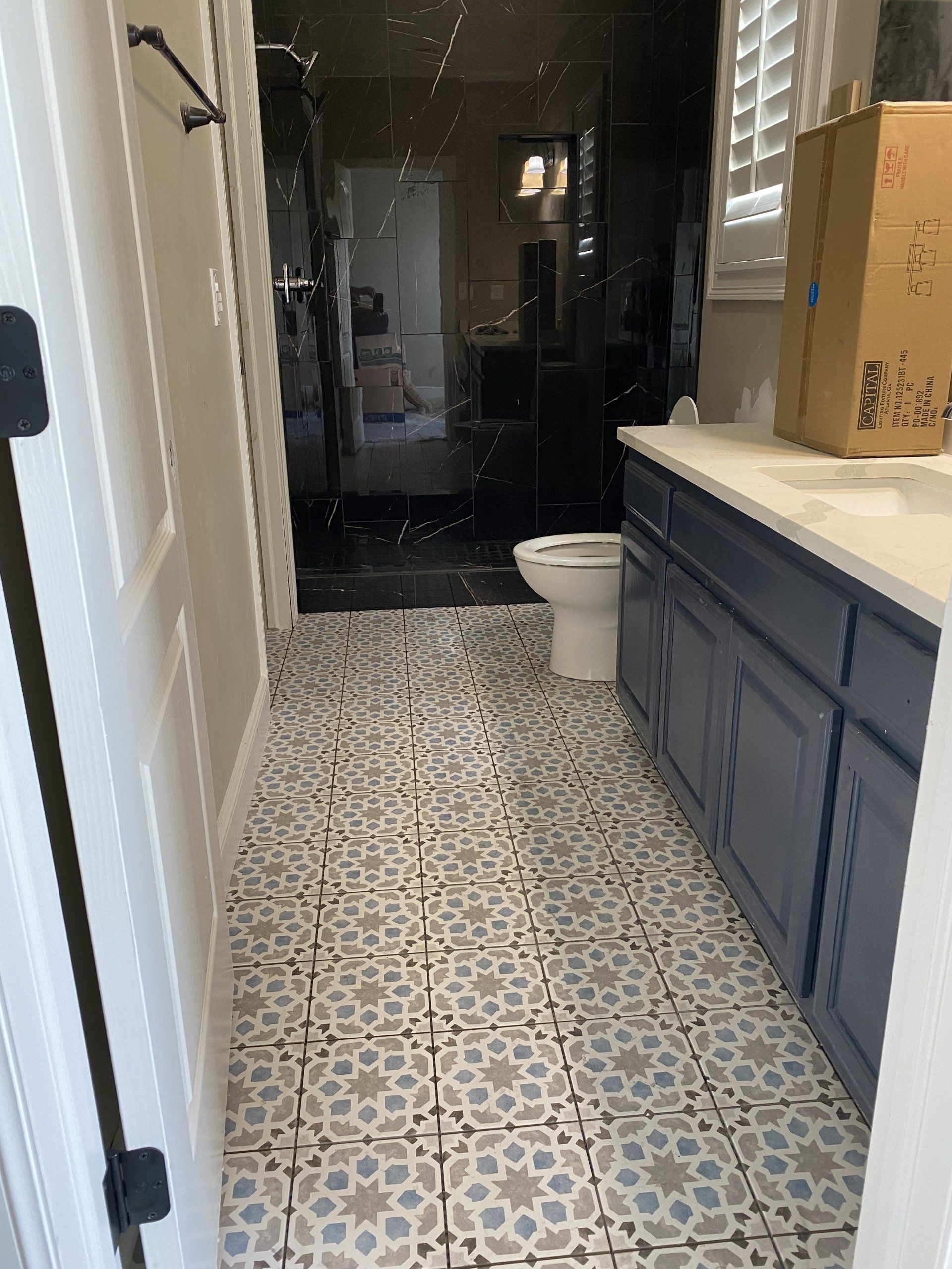 A bathroom with a toilet , sink , and cabinets.