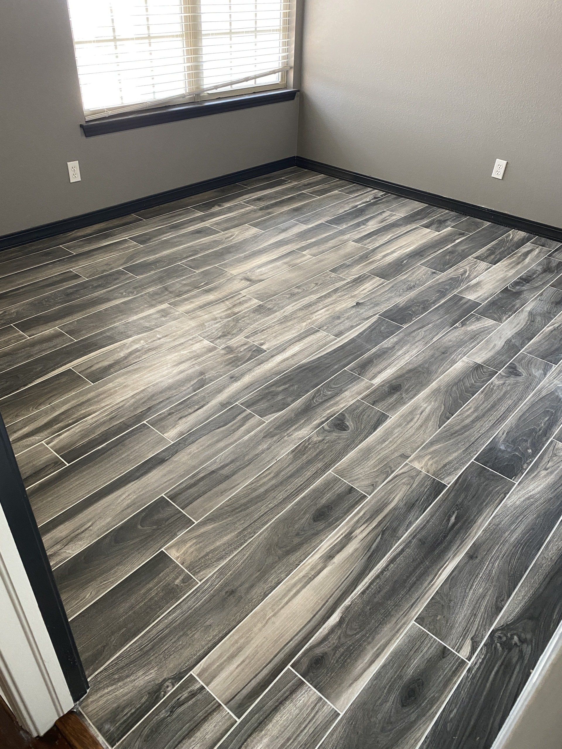 A room with a wooden floor and a window.