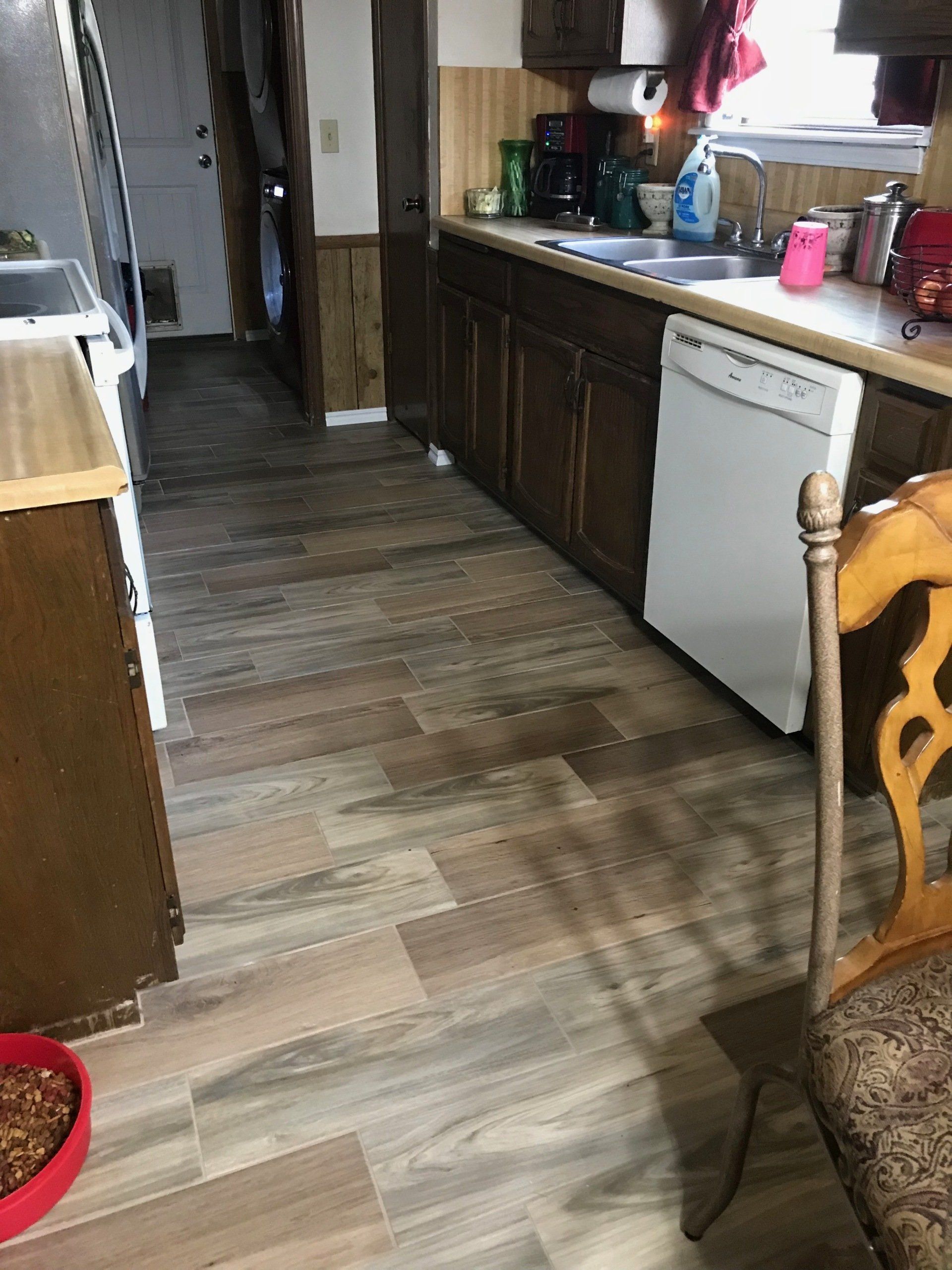 A kitchen with wooden cabinets and a white dishwasher.